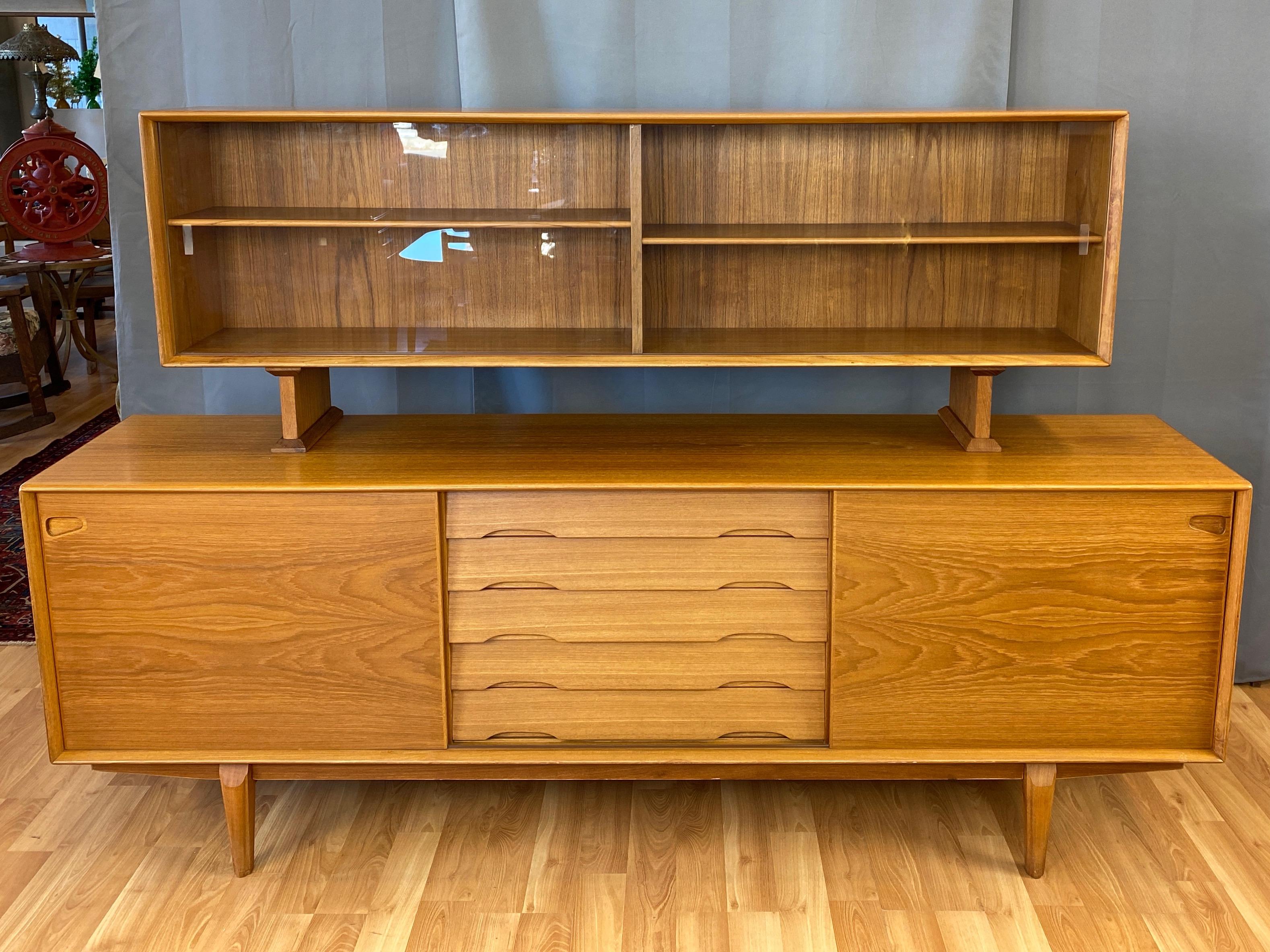 An impressive and uncommon 1960s Danish teak sideboard or credenza and hutch set by Henry Rosengren Hansen for Dyrlund.

Sideboard with a pair of sliding doors that reveal five drawers at center—the top one felt-lined for proper flatware storage—and