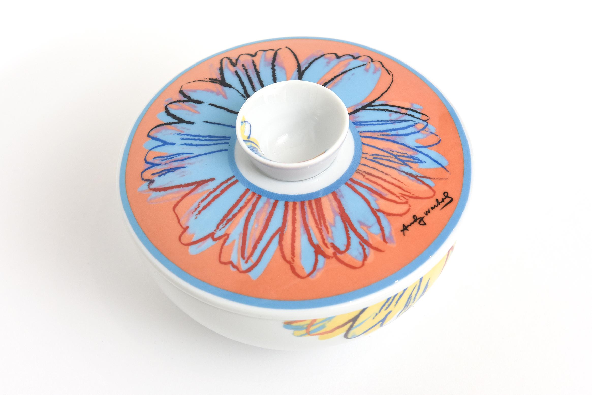 This always wonderful porcelain lidded Rosenthal Studio Line colorful flower sugar bowl or bowl is by a design after Andy Warhol. Signed Andy Warhol. The colors are happy in hues of orange, blue, yellow and red set against the white porcelain. From