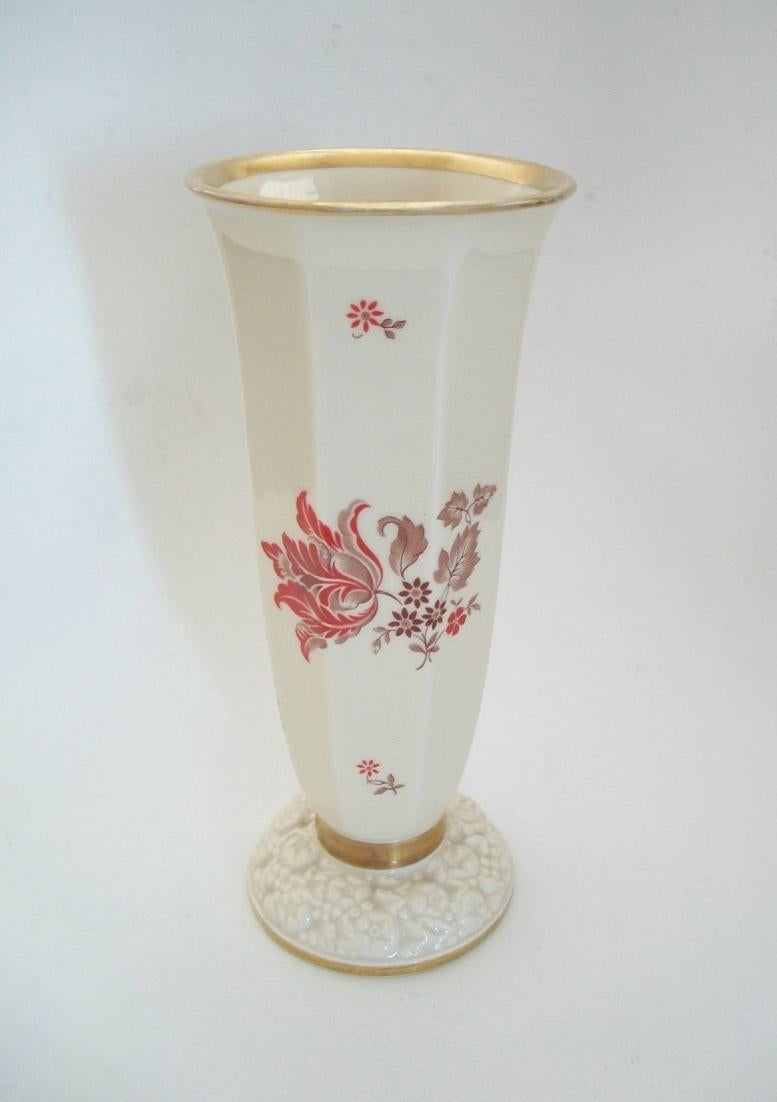 Rosenthal- Art Deco transfer decorated and gilded porcelain trumpet vase - featuring tulips and floral blossoms and leaves to all sides in orange, puce and tan - all on a cream ground with hand applied gilding to the rim, foot and cinched drop waist