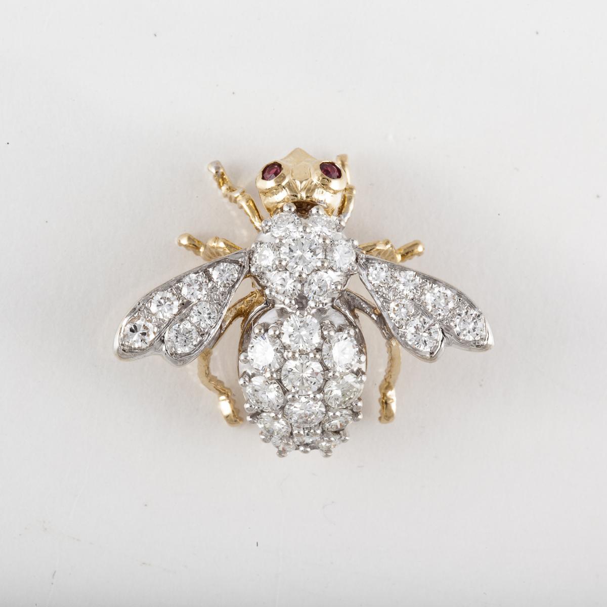 A Rosenthal bee pin in 18K yellow and white gold with diamonds and ruby accents.  The bee has two (2) ruby eyes and thirty-one (31) round diamonds that total 2.85 carats, G-H color and VS1-VS2 clarity.  The pin measures 1 1/4 inches by 1 3/16 inches.