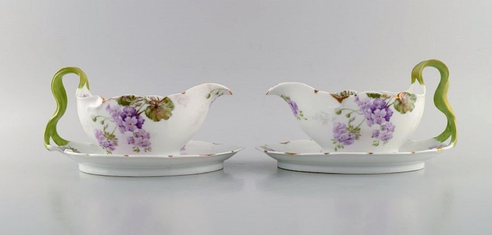 Rosenthal, Germany. 
Two Iris sauce boats in hand-painted porcelain with flowers and gold edge. 
Handles modelled as foliage. 1920s.
Measures: 23 x 15 x 11.5 cm.
In excellent condition.
Stamped.