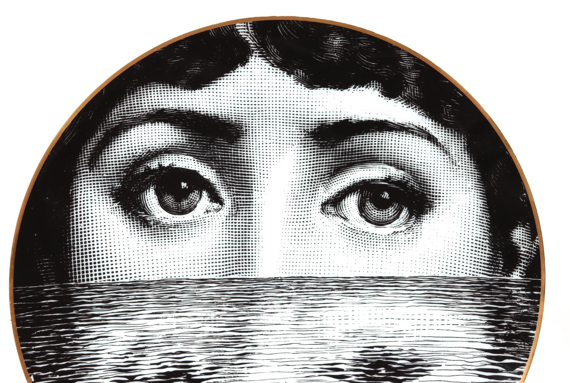 Rosenthal Piero Fornasetti plate, 
Themes & Variations, 
Motiv 9

The striking Rosenthal Fornasetti gold-rimmed black and white printed plate with the face of Lina Cavalieri, her partially exposed face reflected in rippling water with rushes in
