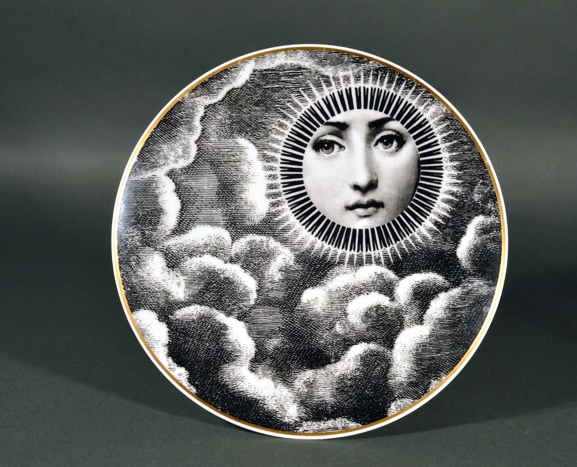 Rosenthal Piero Fornasetti porcelain plate, themes & variations, Motiv 18
The 1980s

The striking Rosenthal Fornasetti gold-rimmed black and white printed plate with the face of Lina Cavalieri depicted as the sun with rays surrounding her face