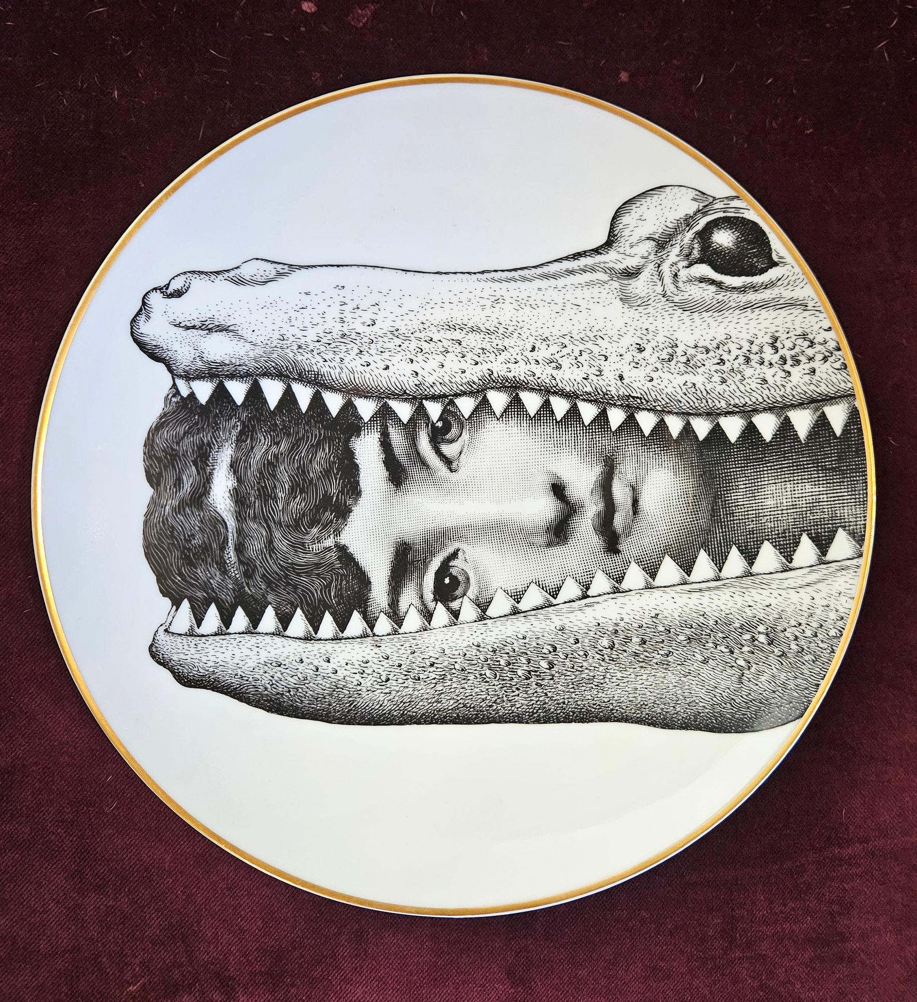 Plato de porcelana Rosenthal Piero Fornasetti Temas y Variaciones,
 Motivo 24,
Cocodrilo,
Con caja original,
1980s

Otros ejemplos disponibles de esta serie.

Llamativa placa Rosenthal Fornasetti impresa en blanco y negro con montura de oro y el