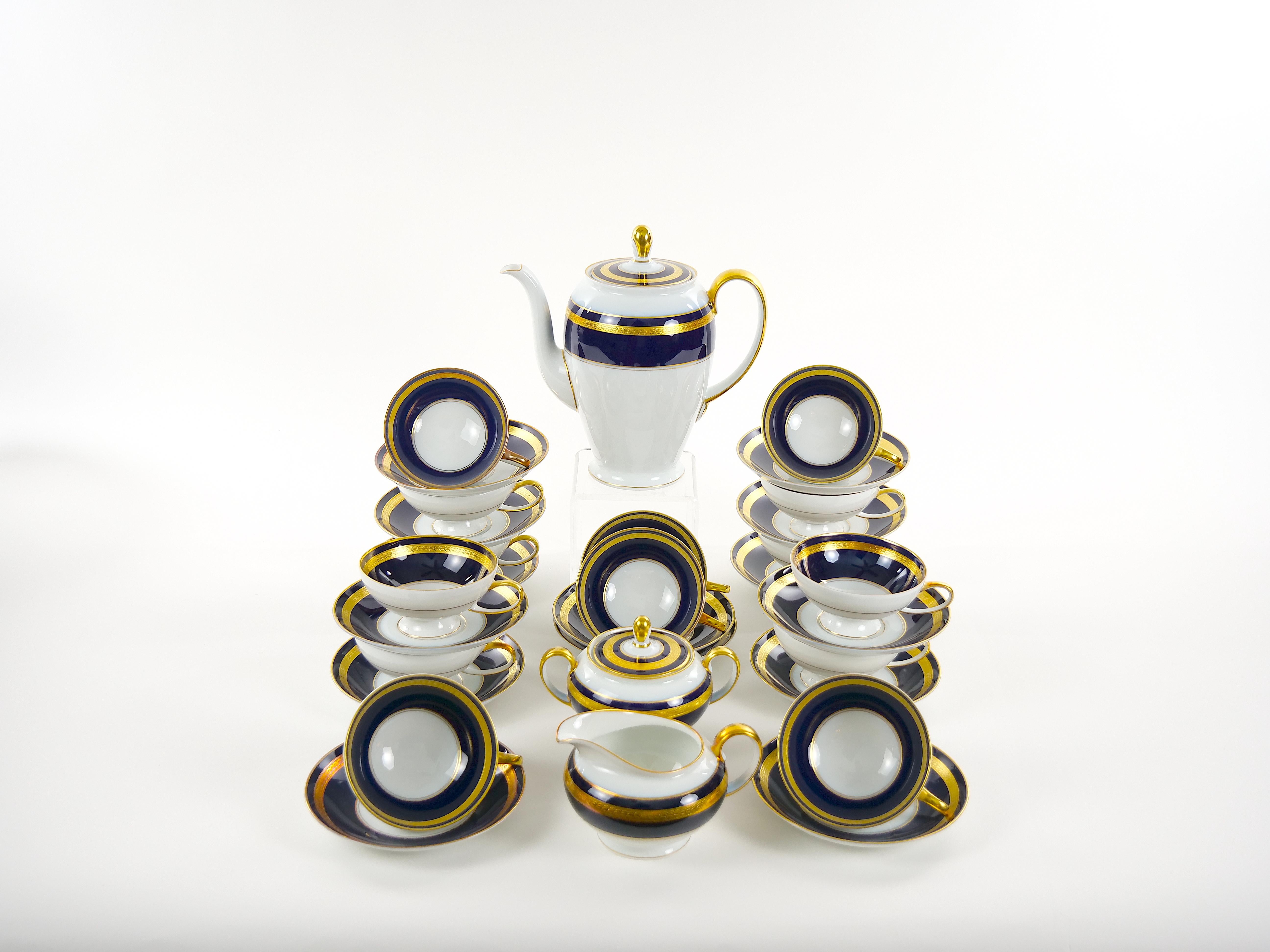 Beautiful  Rosenthal porcelain dinnerware in a cobalt blue with gilt gold design detail in a white background dinner service for fourteen people with serving pieces. Each piece is in excellent condition. Maker's mark undersigned. The set was never