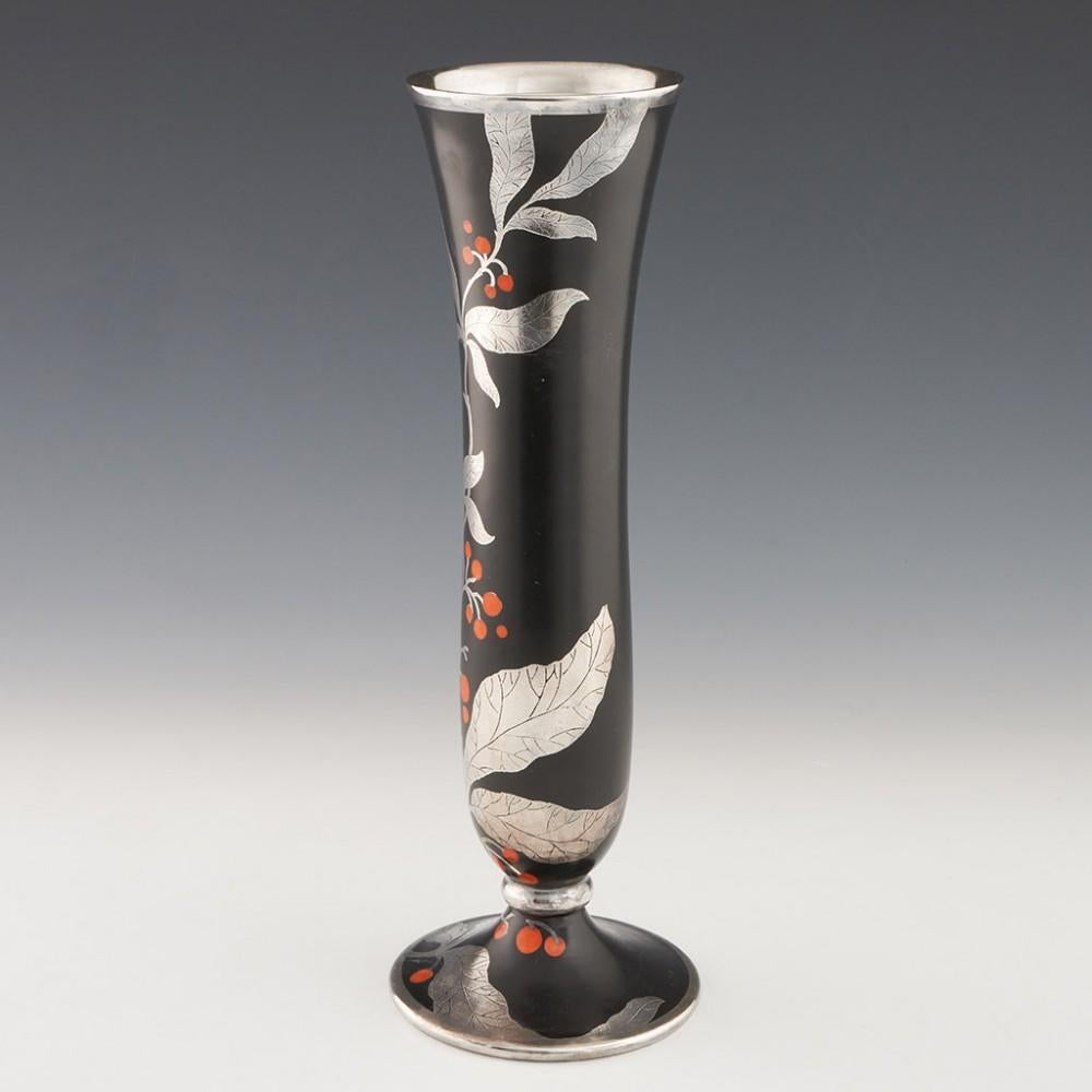 Heading : Rosenthal porcelain silver overlay vase
Date : 1935
Origin : Selb, Germany
Bowl Features : Engraved silver overlay depicting winterberry with red-orange berries over a black ground.
Marks : Rosenthal mark for 1935 to base
Type : Silver