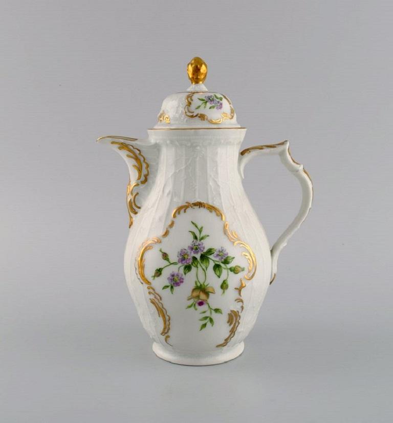 Rosenthal Sanssouci coffee pot, sugar bowl and cream jug. Hand-painted flowers, foliage in relief and gold edge. 
1950s.
The coffee pot measures: 21 x 16 cm.
The sugar bowl measures: 14 x 11.5 cm.
In excellent condition.
Stamped.