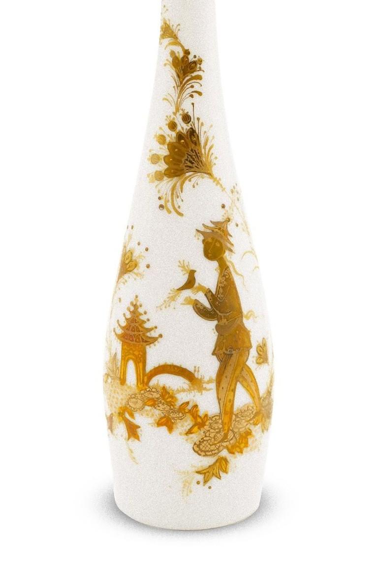 This Rosenthal vase is a decorative object designed by Bjorn Wiinblad and realized by Rosenthal during the mid-20th century.

Soliflore vase in white porcelain decorated with a golden Japanese motif.

Hand-signed in ink by the artist; dated