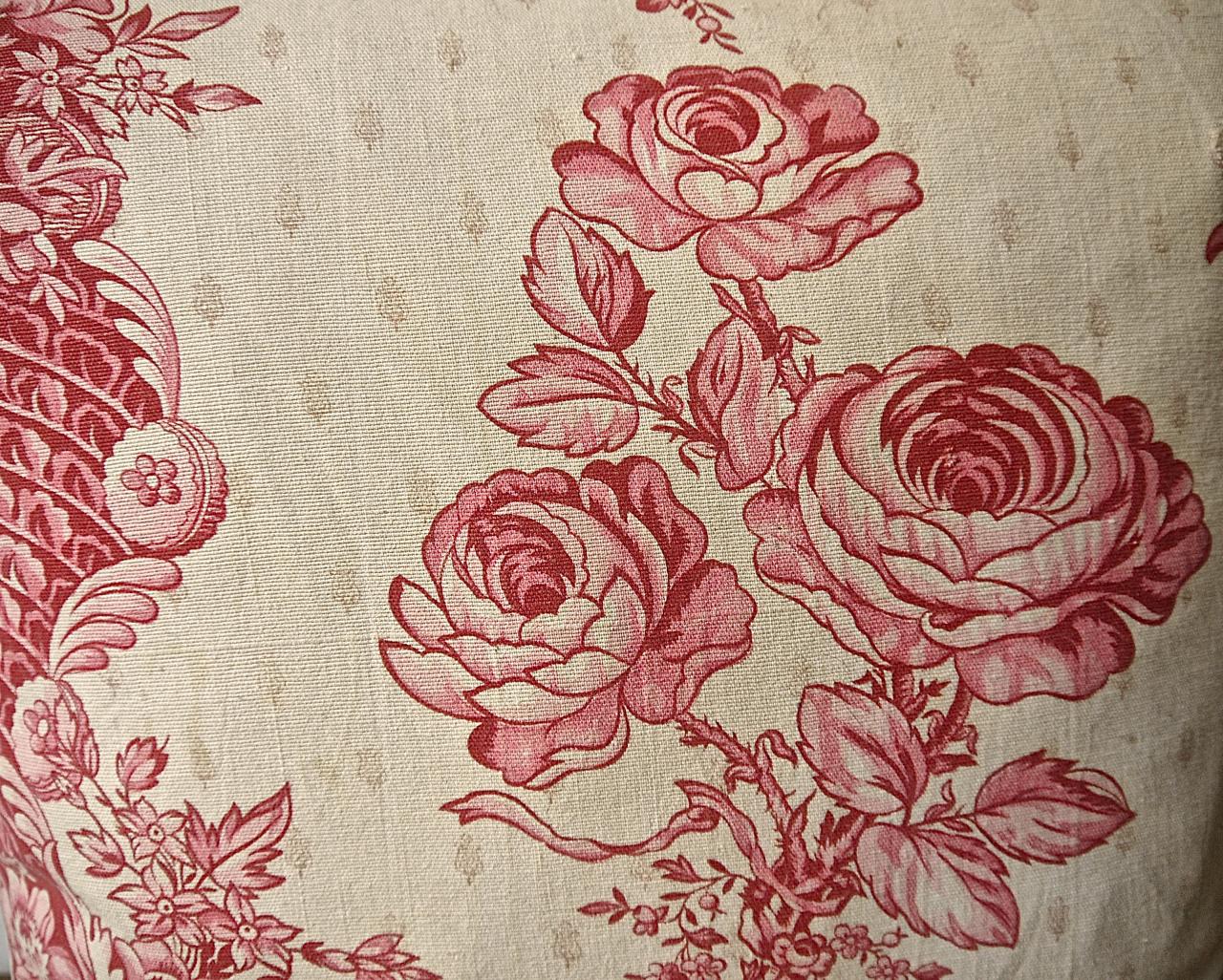 French later 19th century cushion printed with a design based on an 18th century original. Pretty blowsy raspberry red and pink roses gathered with a ribbon alternating with twisting columns of flowers against a faintly motif printed ground. With