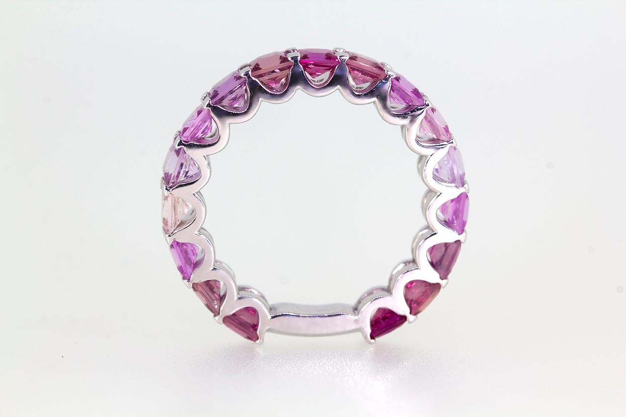 The Rosetta Pink Ombre Sapphire 18 Carat White Gold Eternity Band Ring is a coveted piece measuring approximately 3.52mm in width. The ring features one row of 17 x scalloped claw settings of an ombre effect of pink natural, no heat sapphires in