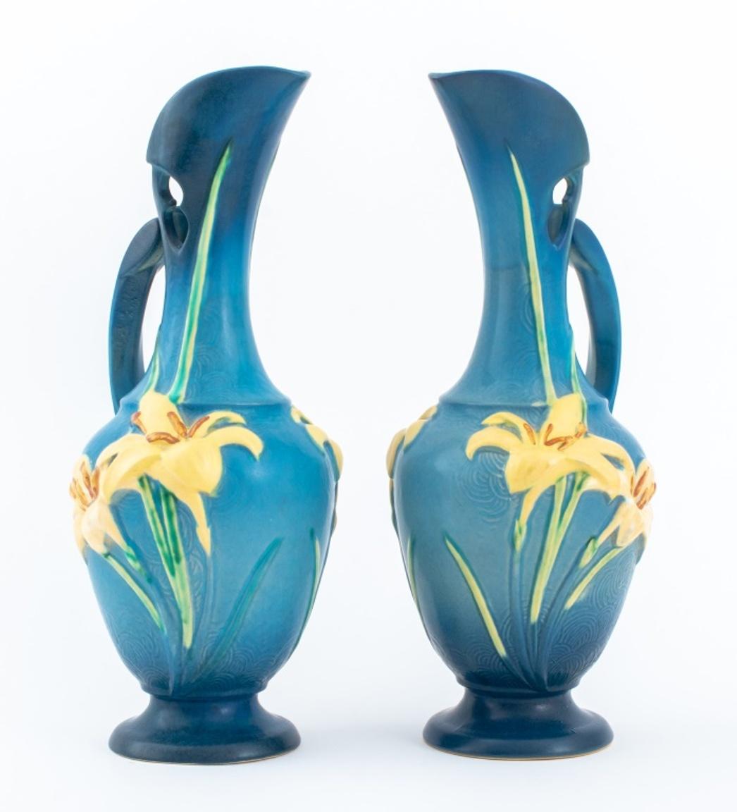 Pair of Roseville Pottery ceramic pitchers in the Zephyr Lily pattern on blue glazed grounds, each marked 