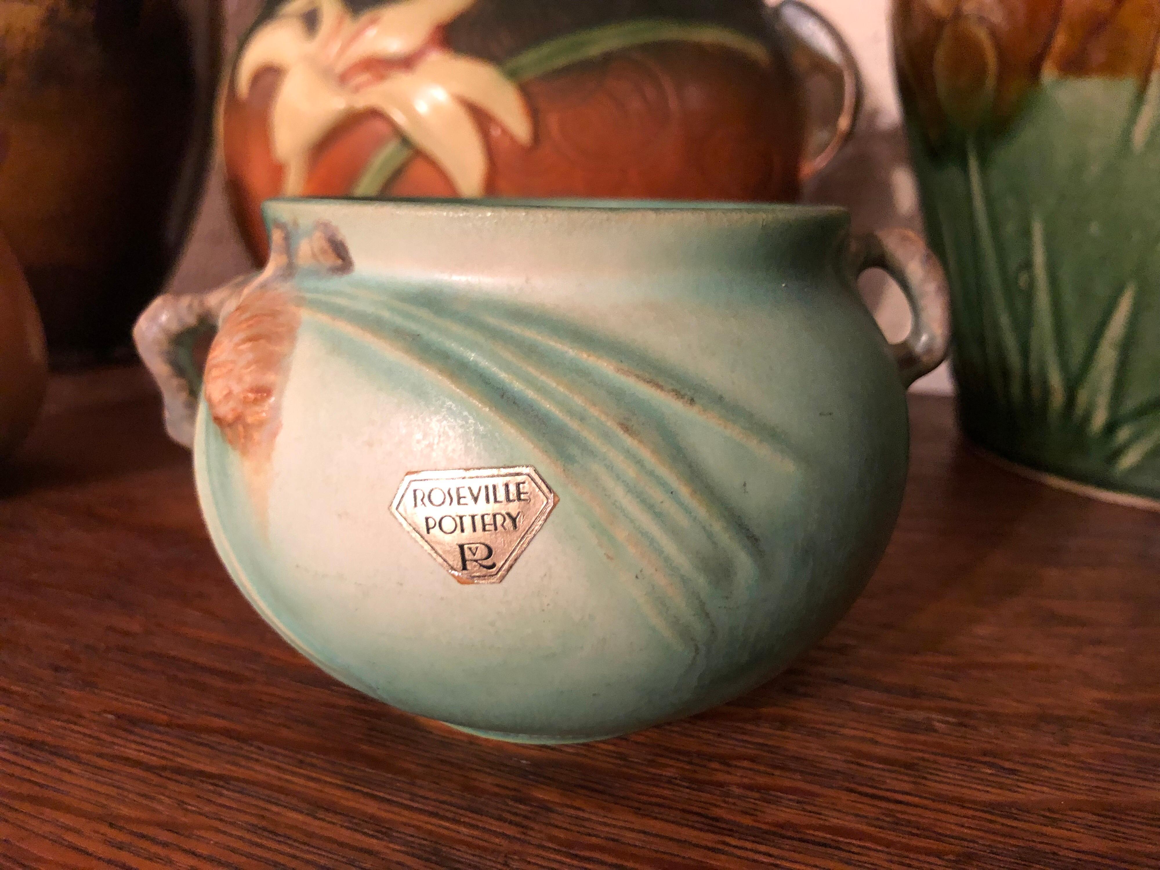 Roseville Pinecone pot with original labels. Lovely earth tone greens and rust. Original labels and in excellent condition.
Pine Cone is a popular pattern introduced by Roseville Pottery in 1935. Many collectors spell the pattern pinecone. Pinecone