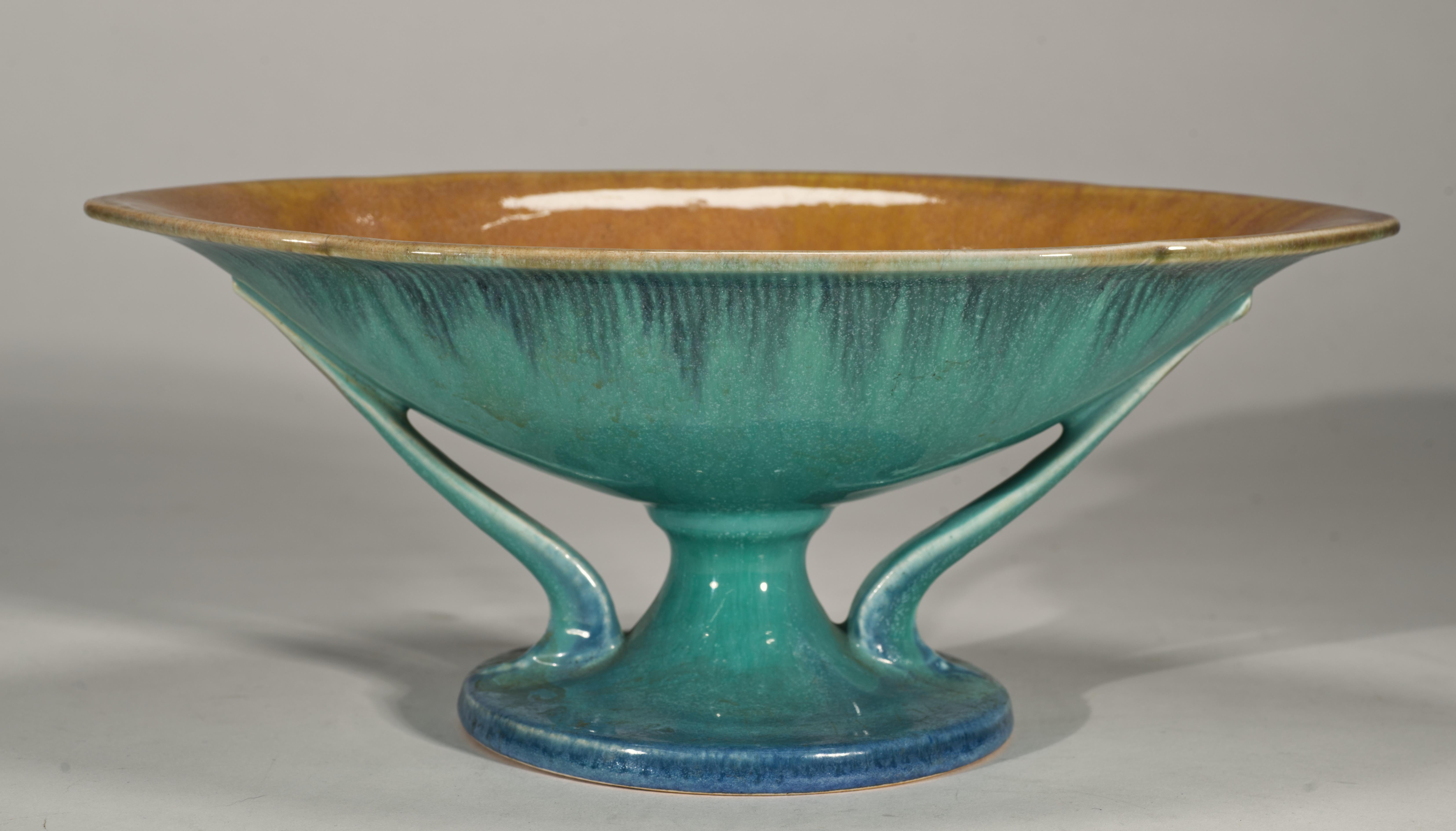  El cuenco vintage Roseville Pottery presenta un esmalte azul turquesa con un ribete pintado a mano en la parte superior del cuerpo de cerámica, ejecutado como una serie de líneas verticales cortas de color azul oscuro. Las superficies interiores