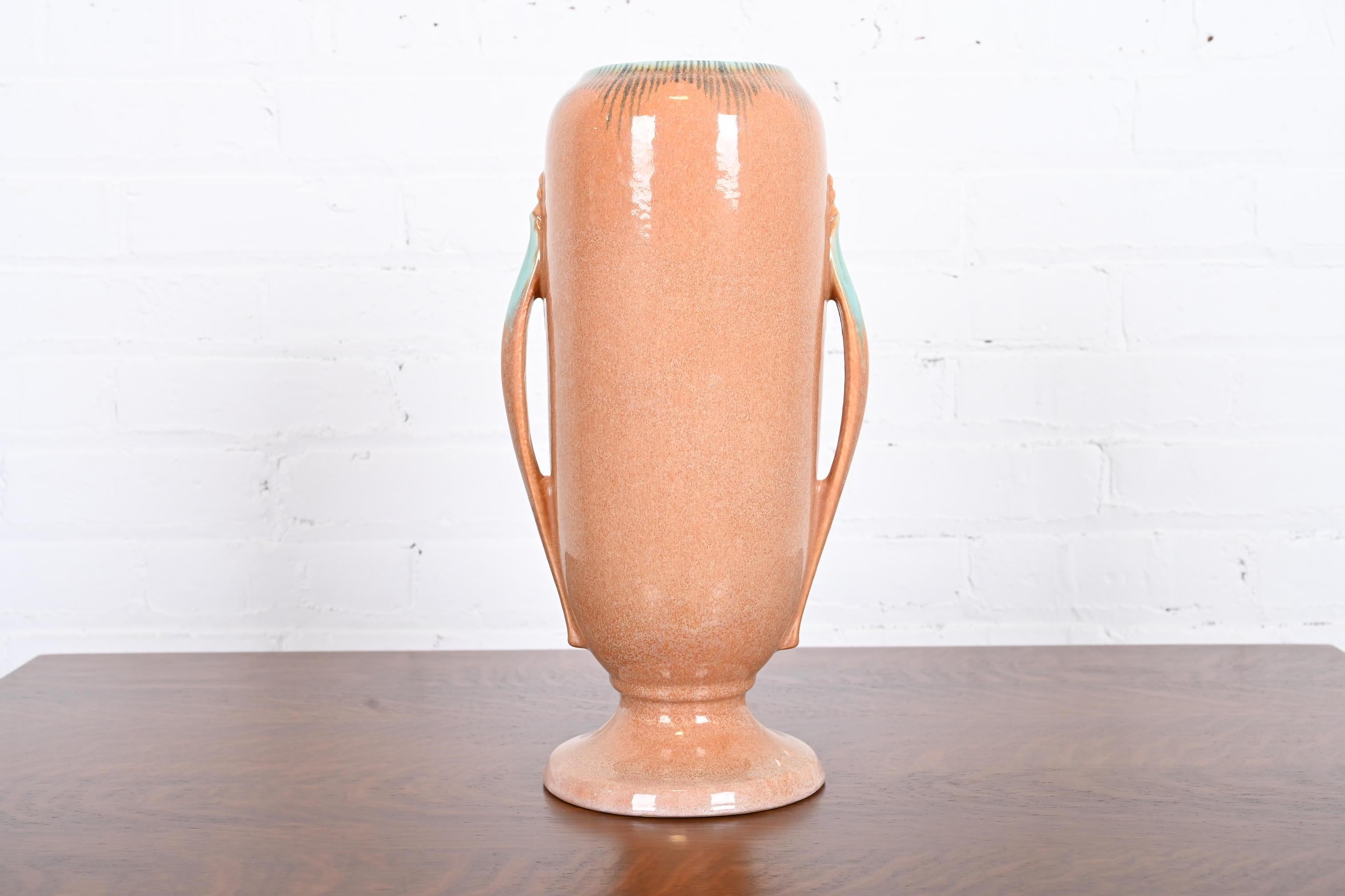 Magnifique vase Art déco en poterie d'art à anses émaillées

Par Roseville Pottery

États-Unis, années 1930

Céramique émaillée d'une belle couleur pêche et turquoise.

Dimensions : 7,5 