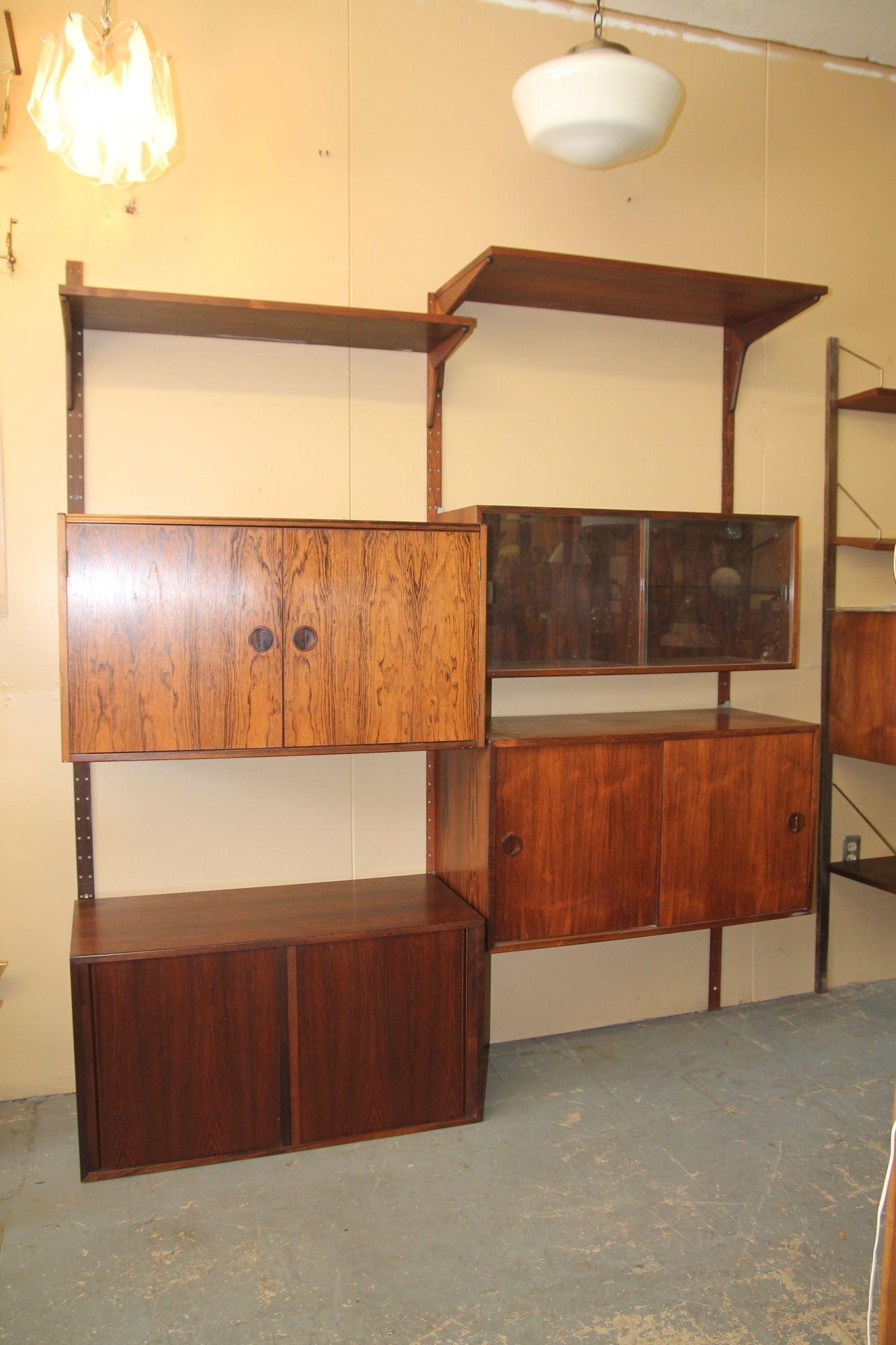 Pleased to offer this great two bay rosewood Cado wall unit.  Set includes 2 shelves ( 12 x 35 1/4 and 16 x 35 1/4), cabinet that opens from top and front, cabinet with glass sliding doors and one glass shelf, sliding door cabinet with 2 shelves and