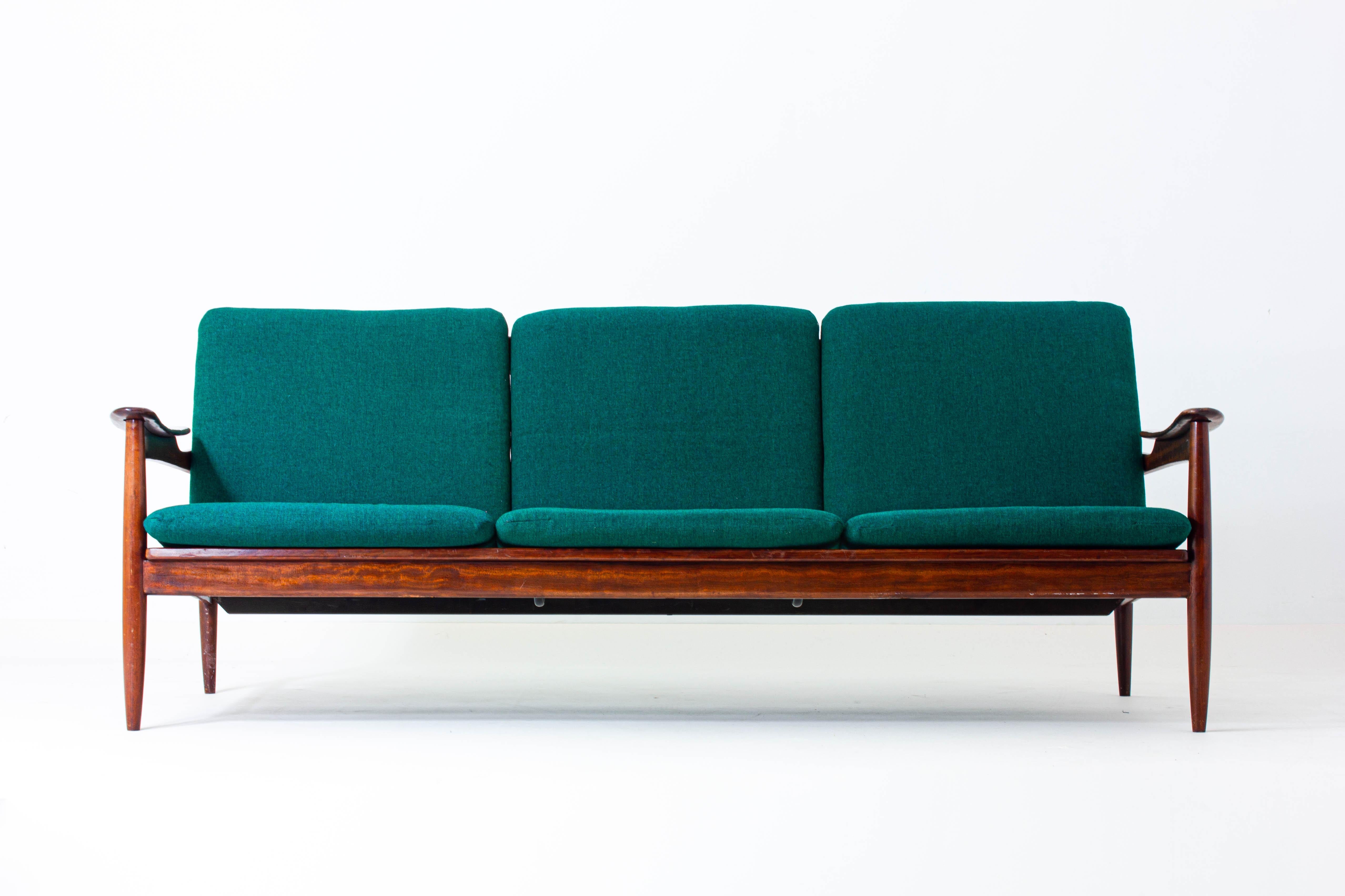 This very elegant Danish mid century three-seater from the 60s was made with premium rosewood and comes in an emerald green upholstery.

Thanks to its subtle, but refined presence, this stunner can be used as a main seating element or as a