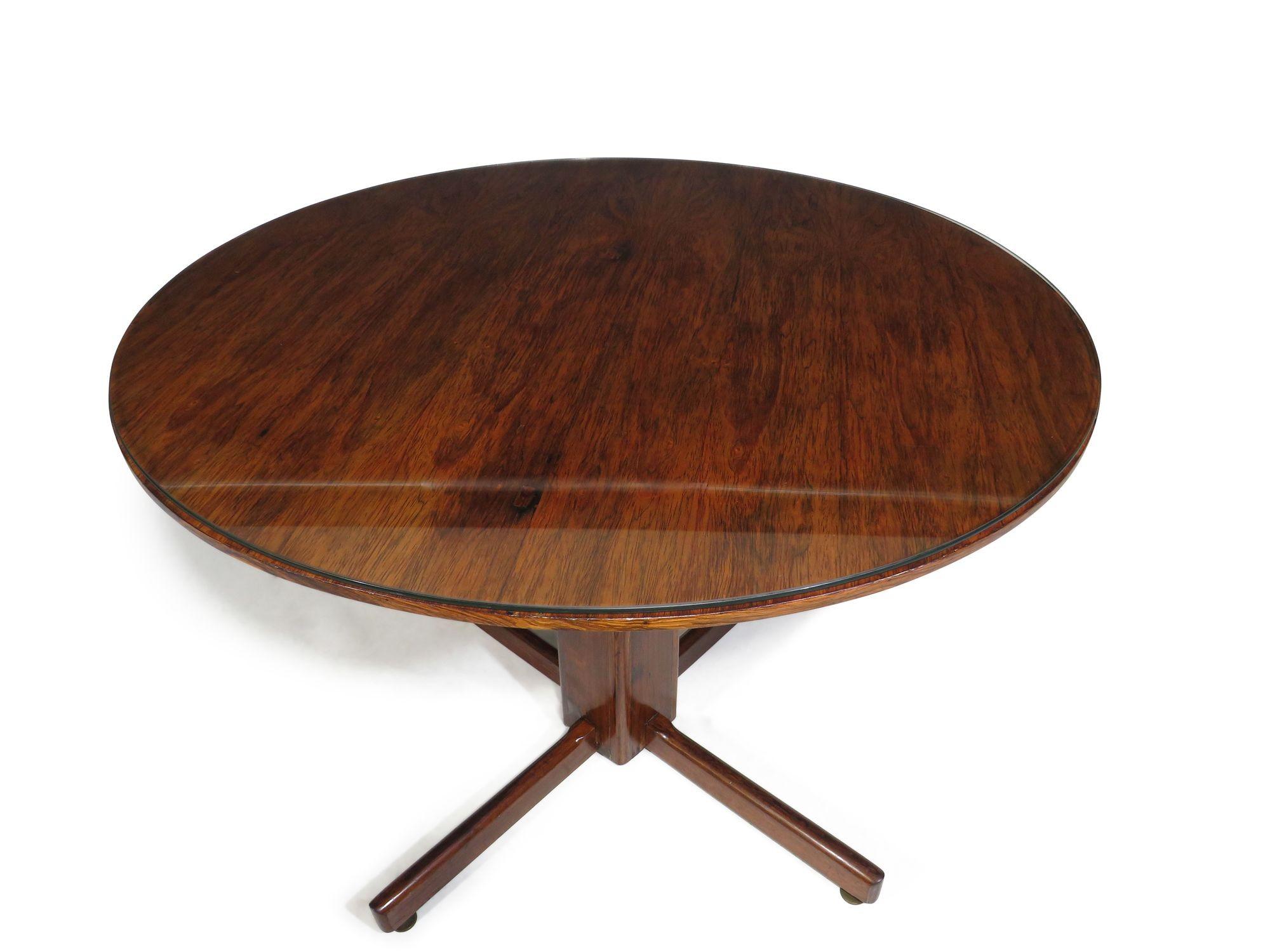 Brazilian Rosewood dining table in the manner of Sergio Rodriques' Alex table. The table is crafted of rosewood on pedestal base with glass top.
Measurements 
Diameter 42''
Height 30.75''