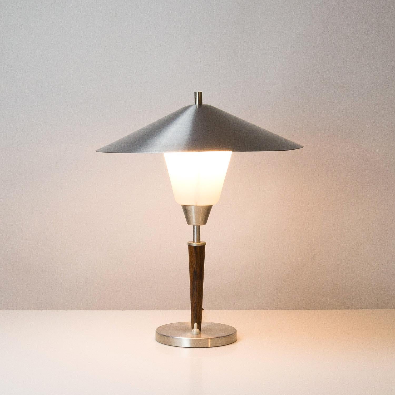 A rare 1950s rosewood, aluminium and opaline glass table lamp by Fog & Mørup, Denmark.
    