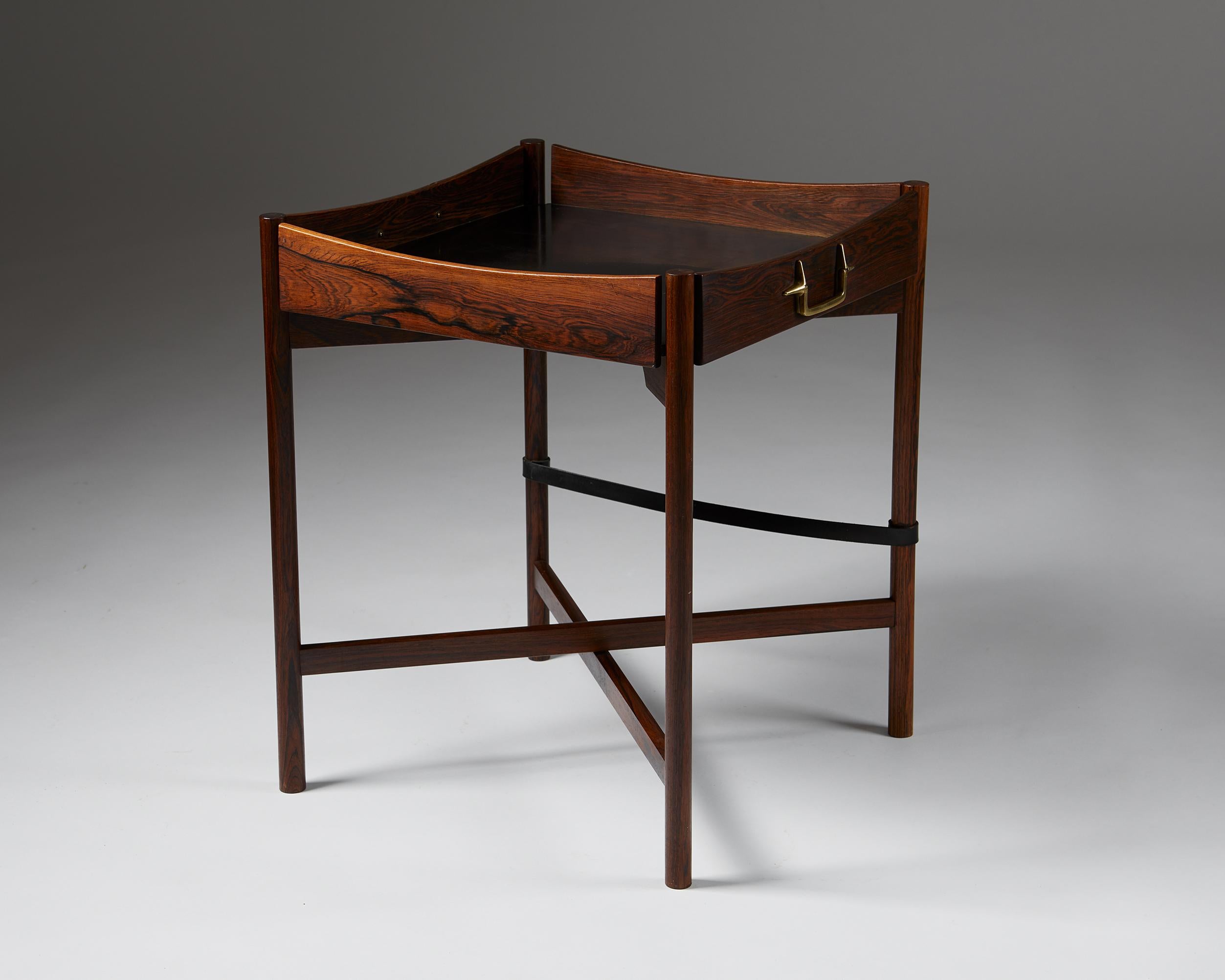 Tray table designed by Mogens Lysell,
Denmark, 1960s.

Brazilian rosewood, brass & black formica.

This Brazilian rosewood tray table was designed by the Danish designer Mogens Lysell in the 1960s. Even today, rosewood is considered to be both