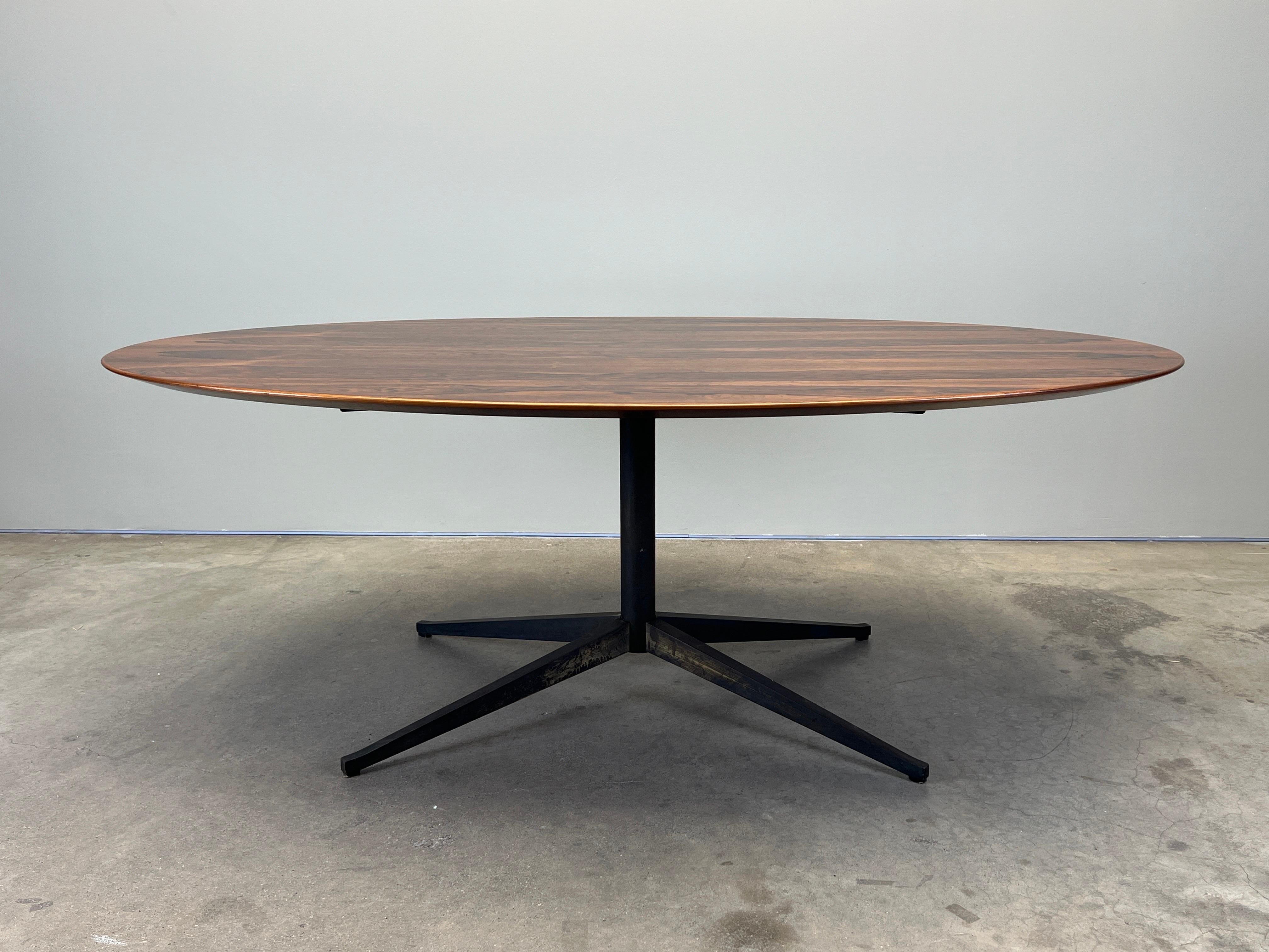 Table bureau elliptique en bois de rose magnifiquement grainé avec base en bronze patiné. Conçu par Florence Knoll pour Knoll. 