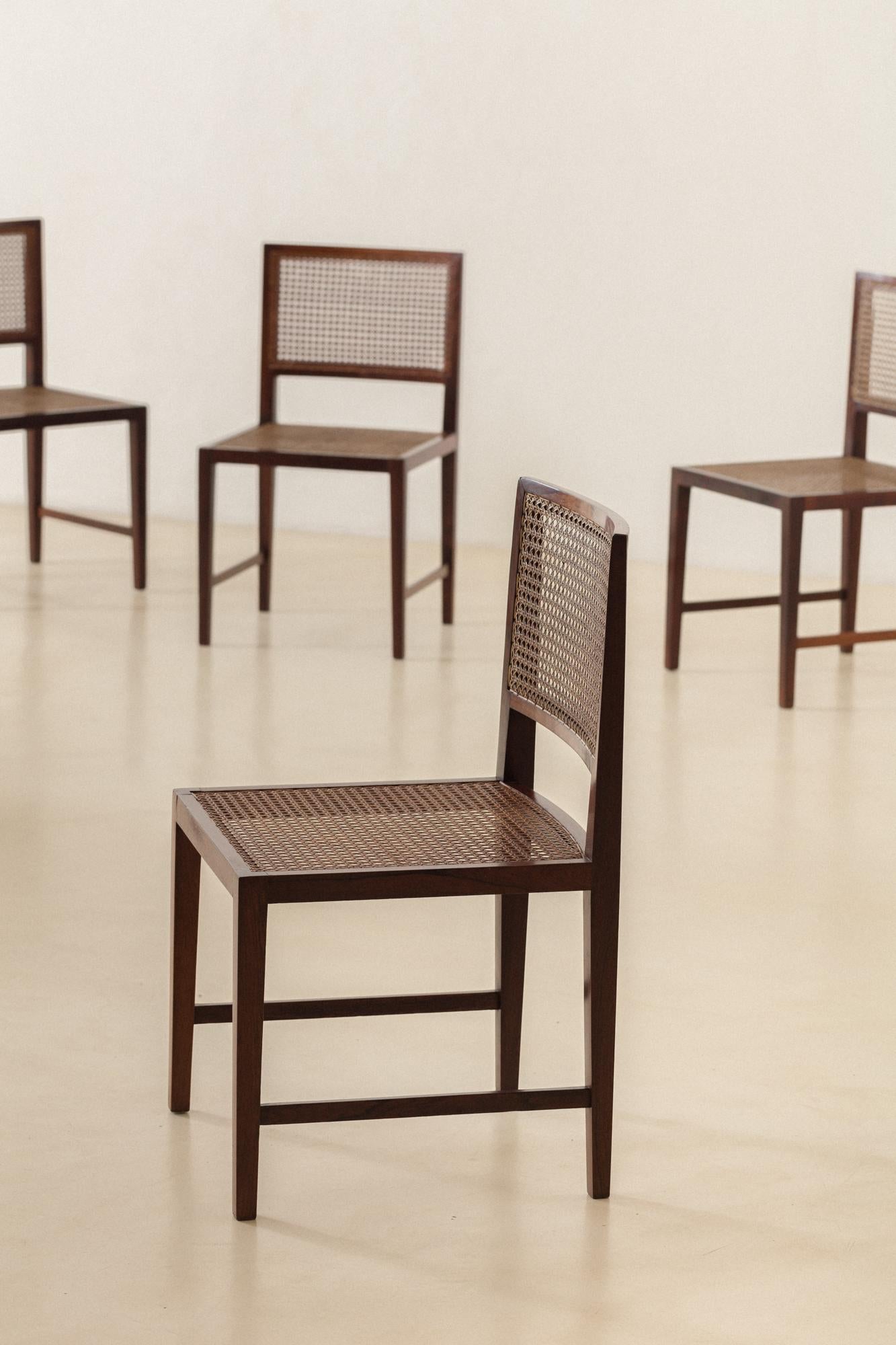 ML Magalhães produced this set of eight dining chairs in the 1960s. The pieces have solid Rosewood structure and seats and backrests in natural plaited cane. 

With rectangular forms and corners in almost all the structure, one beautiful detail to