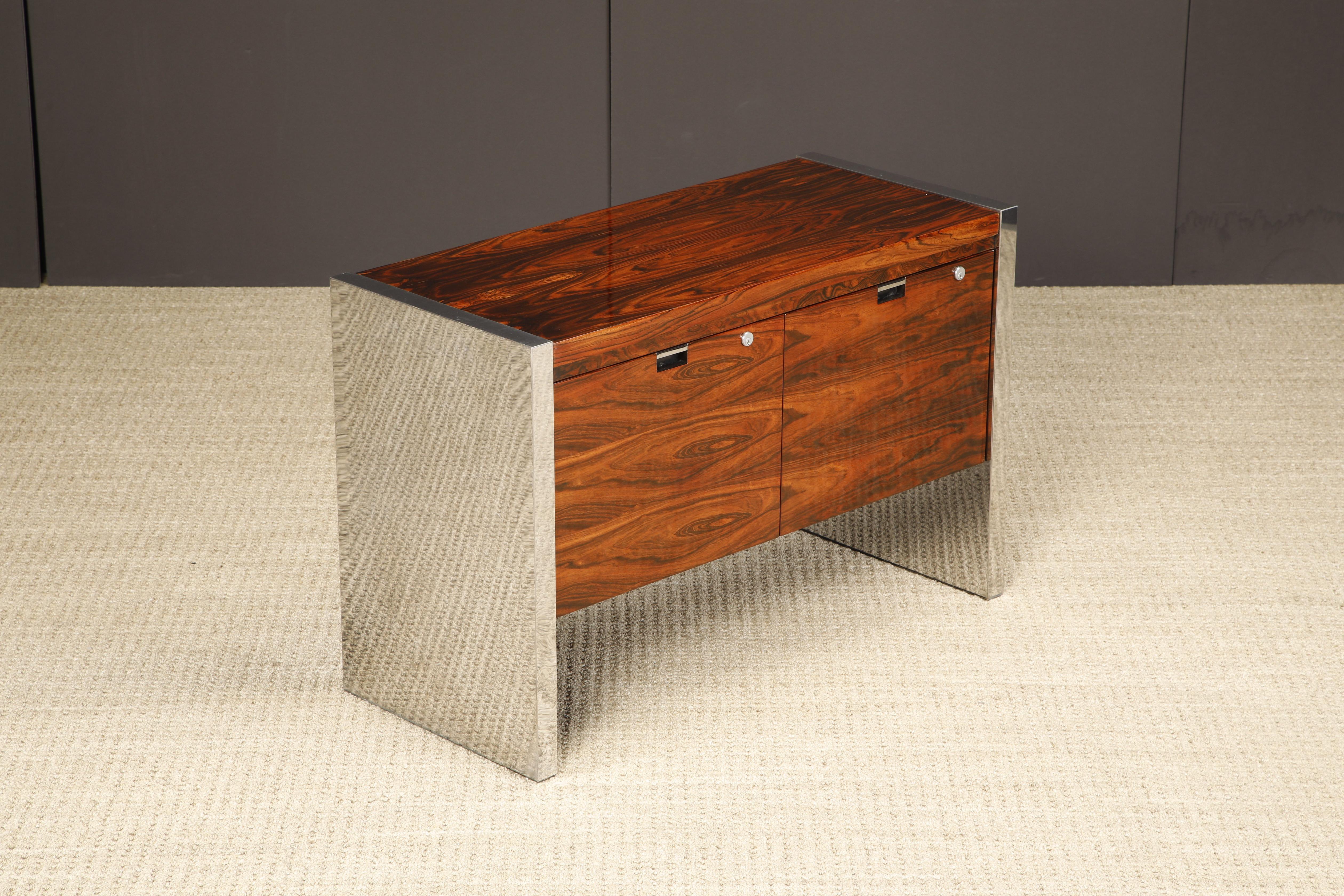 This exotic grained Rosewood and chrome executive credenza by Roger Sprunger for Dunbar features beautifully refinished Rosewood with a pair of signature chrome paneled legs, designed and made in the 1970s. Signed with Dunbar tag as can be seen in