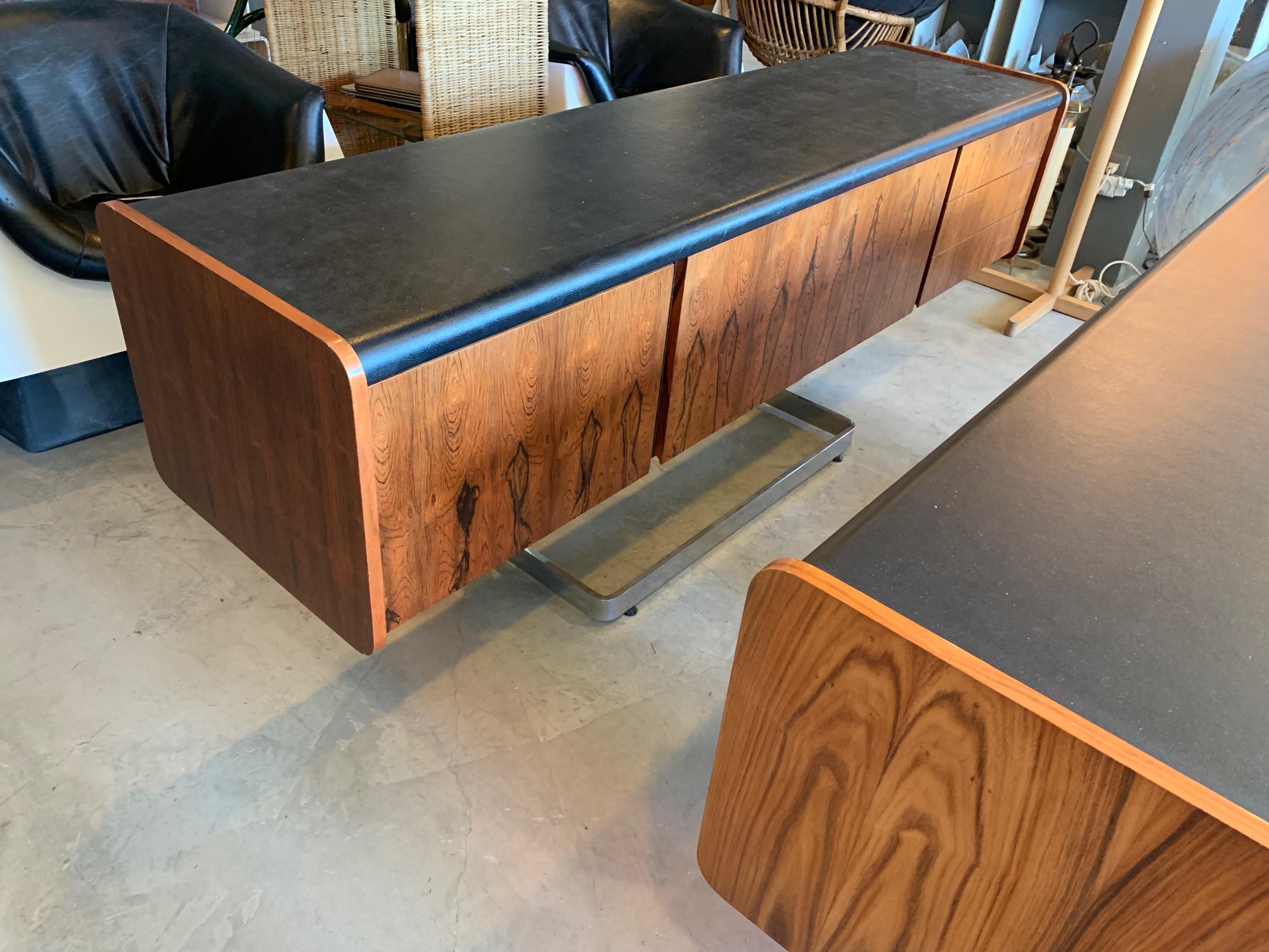Stunning credenza by Ste. Marie & Laurent. Floating rosewood frame with cantilevered chrome base. Three drawers on the right and large functional file drawer on the left. Original locks in great working condition with keys. 2 cupboard doors in the