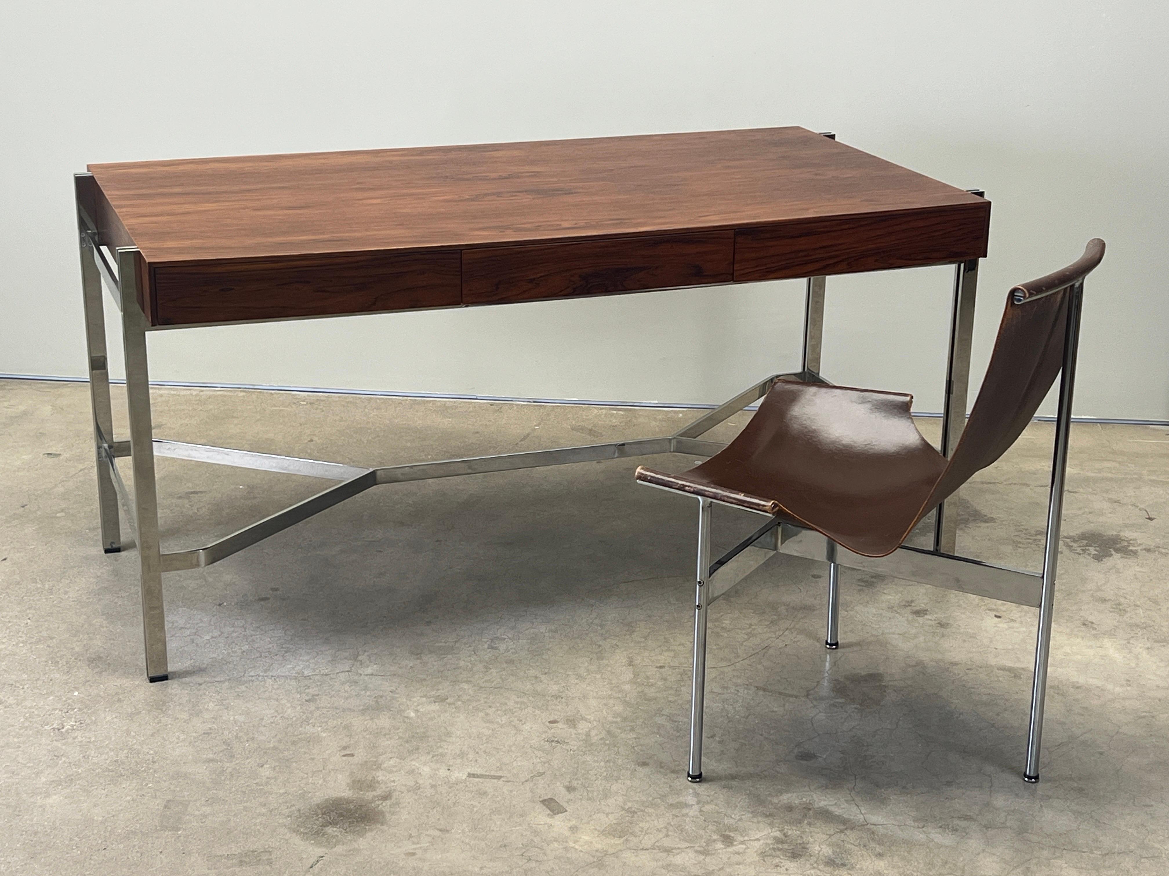 A rosewood desk with solid chromed steel base and three drawers. Attributed to Milo Baughman for Thayer Coggin. 
