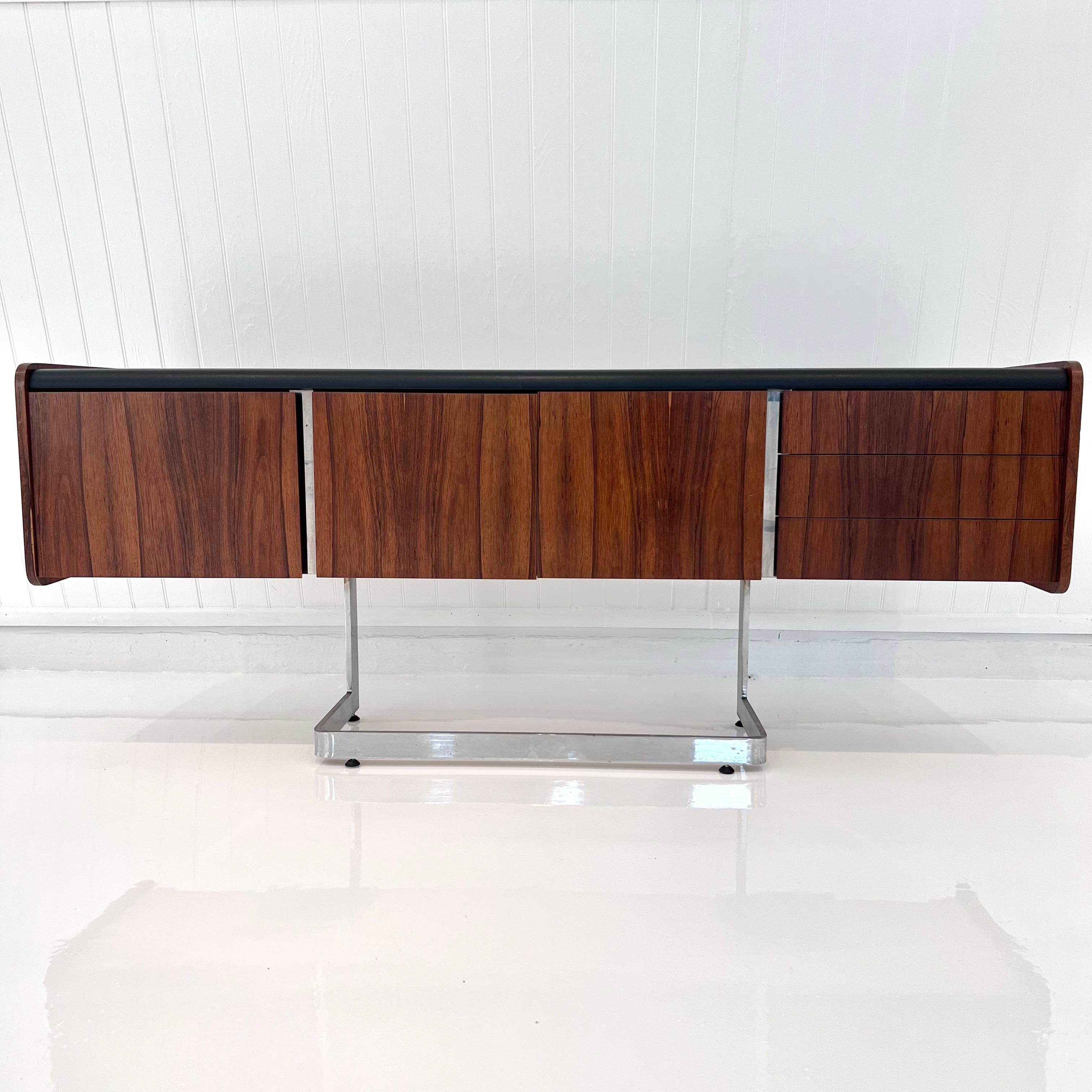 Stunning credenza by Ste. Marie & Laurent made in the 1970s, Canada. Floating rosewood and vinyl desk with angular chrome base. One large drawer on the left hand side as well as the center and 3 small drawers on the right hand side. Black vinyl top