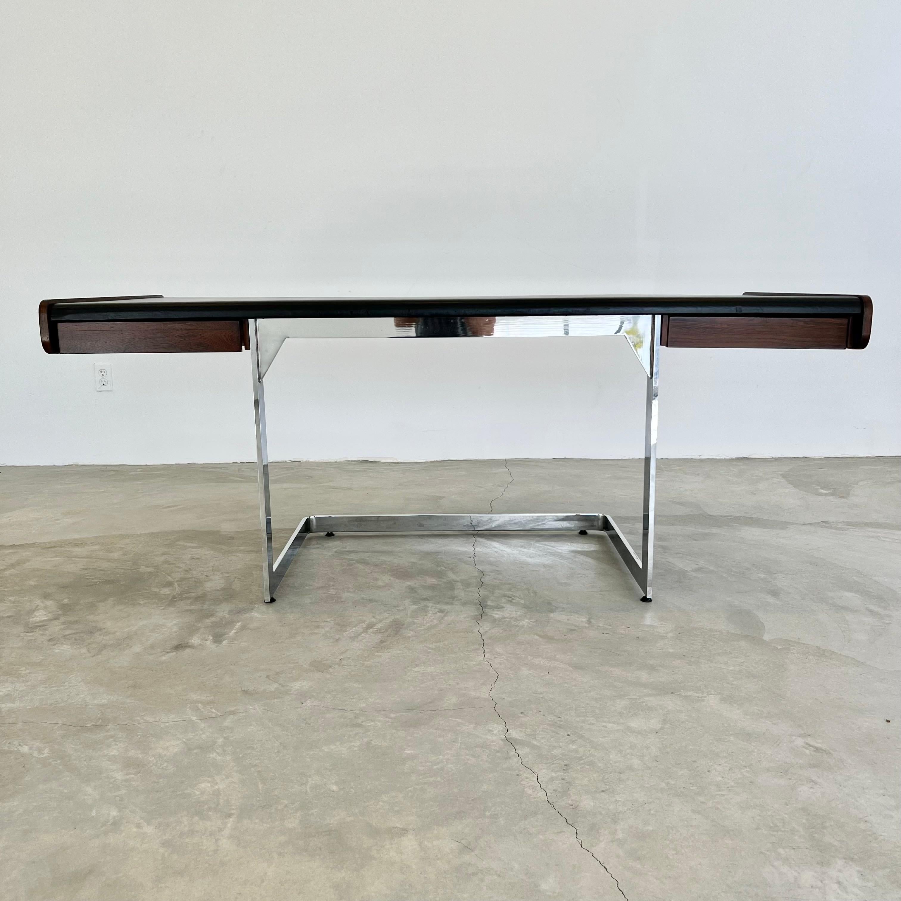 Stunning desk by Ste. Marie & Laurent made in the 1970s, Canada. Floating rosewood and vinyl desk with angular chrome base. One-drawer flanks each side of the desk. Black vinyl top and wood in good condition with some wear as shown. Elegant lines