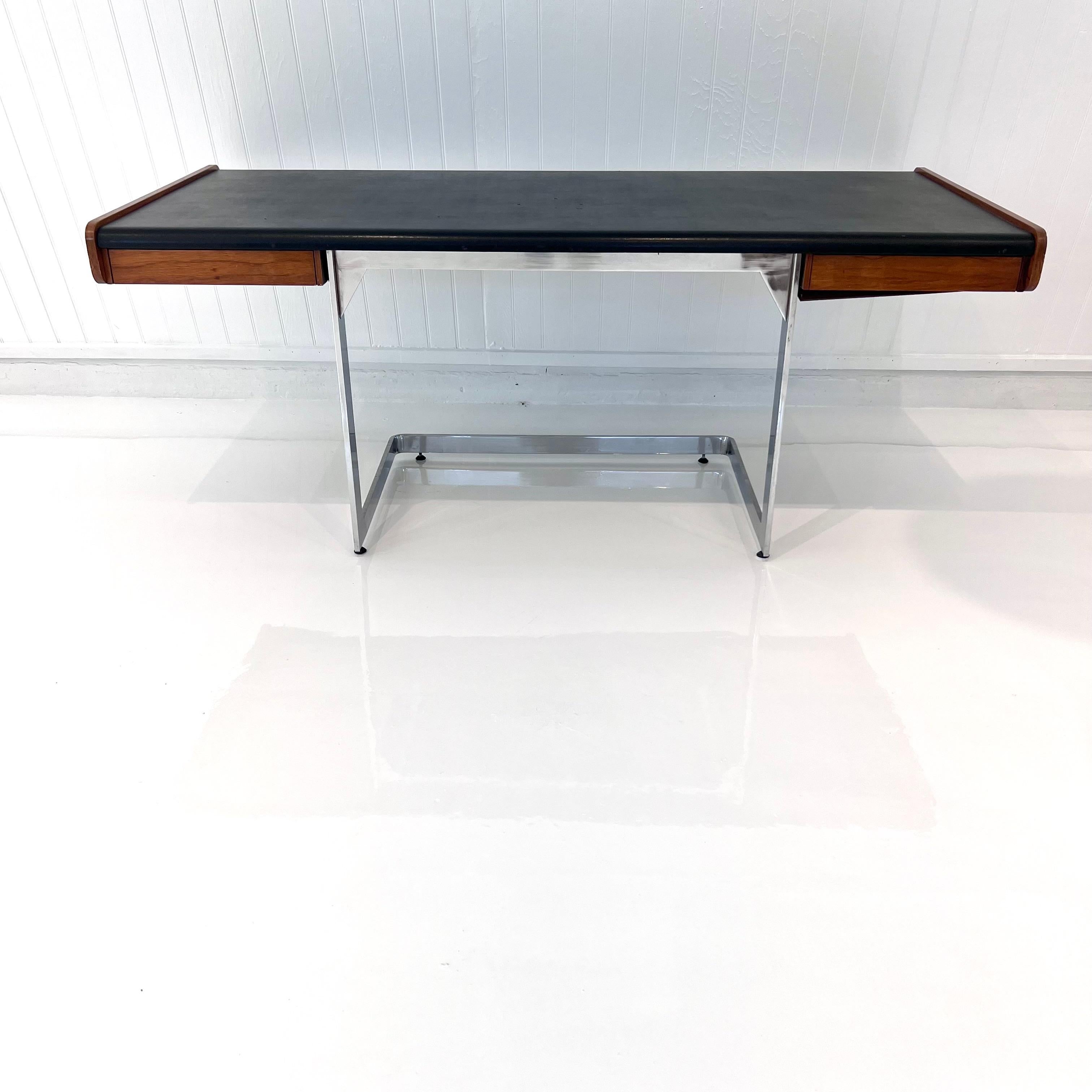 Stunning desk by Ste. Marie & Laurent made in the 1970s, Canada. Floating Rosewood and vinyl desk with angular chrome base. One-drawer flanks each side of the desk. Black vinyl top and wood in good condition with some wear as shown. Elegant lines