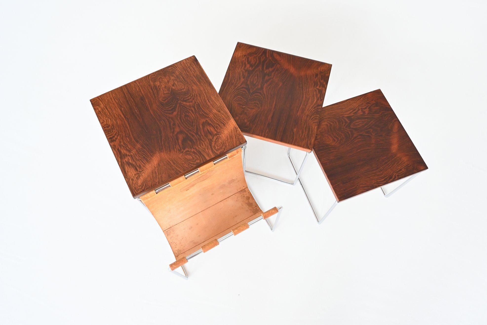 Beautiful set of three nesting tables by unknown designer or manufacturer, The Netherlands 1960. These tables have a chrome plated solid metal sled frame, nicely grained rosewood veneered top and a patinated natural saddle leather magazine basket.