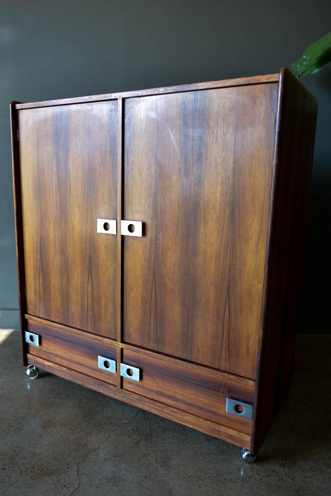 Rosewood and chrome rolling dry bar or cabinet by Leif Jacobsen, circa 1970. Beautiful grained rosewood with polished chrome hardware and casters. Could be used as a dry bar as well as for clothing/storage as a cabinet. Very good original condition