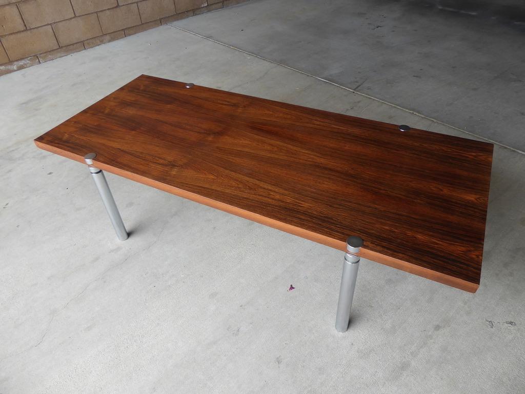 A rectangular rosewood and chrome-plated metal coffee table, circa 1970s. The Rosewood grain on the top of the table is beautifully figured and bookmatched.