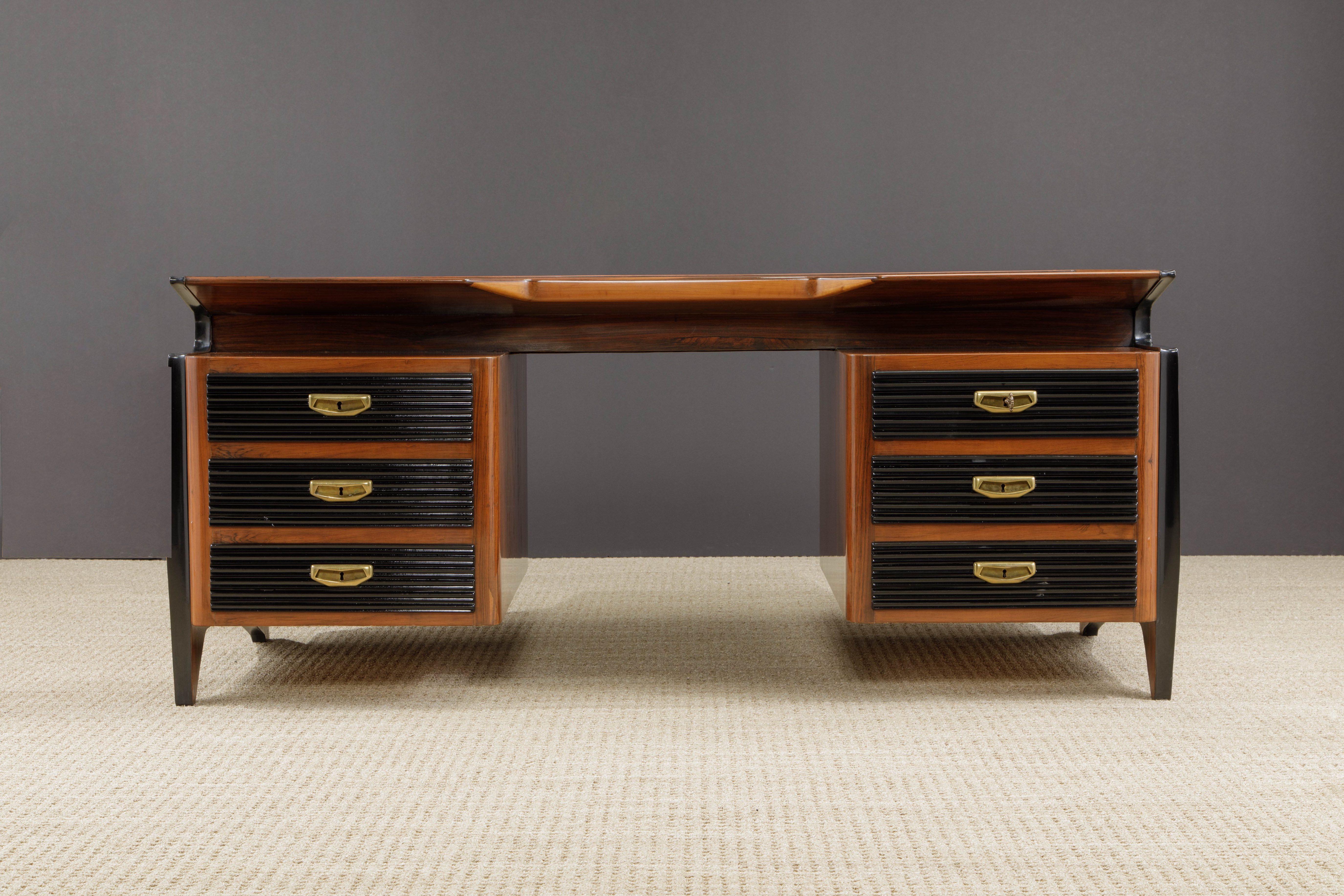 This incredible Italian Modernist Rosewood and Ebonized desk is attributed to Osvaldo Borsani and shares many similarities to designs by Gio Ponti. From its striking angular legs, floating pedestals and cut-out top to the ebonized ribbed drawers