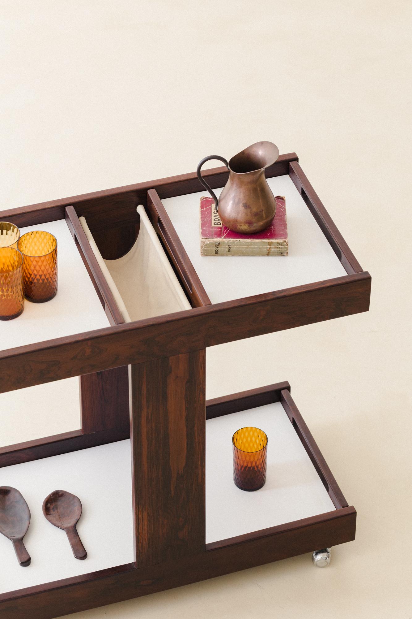 This bar cart made of Brazilian Rosewood and Formica was produced by Celina Decorações in the 1960s. This piece appears in several interior projects and magazine articles from the period.

The cart has two levels, and both are composed of