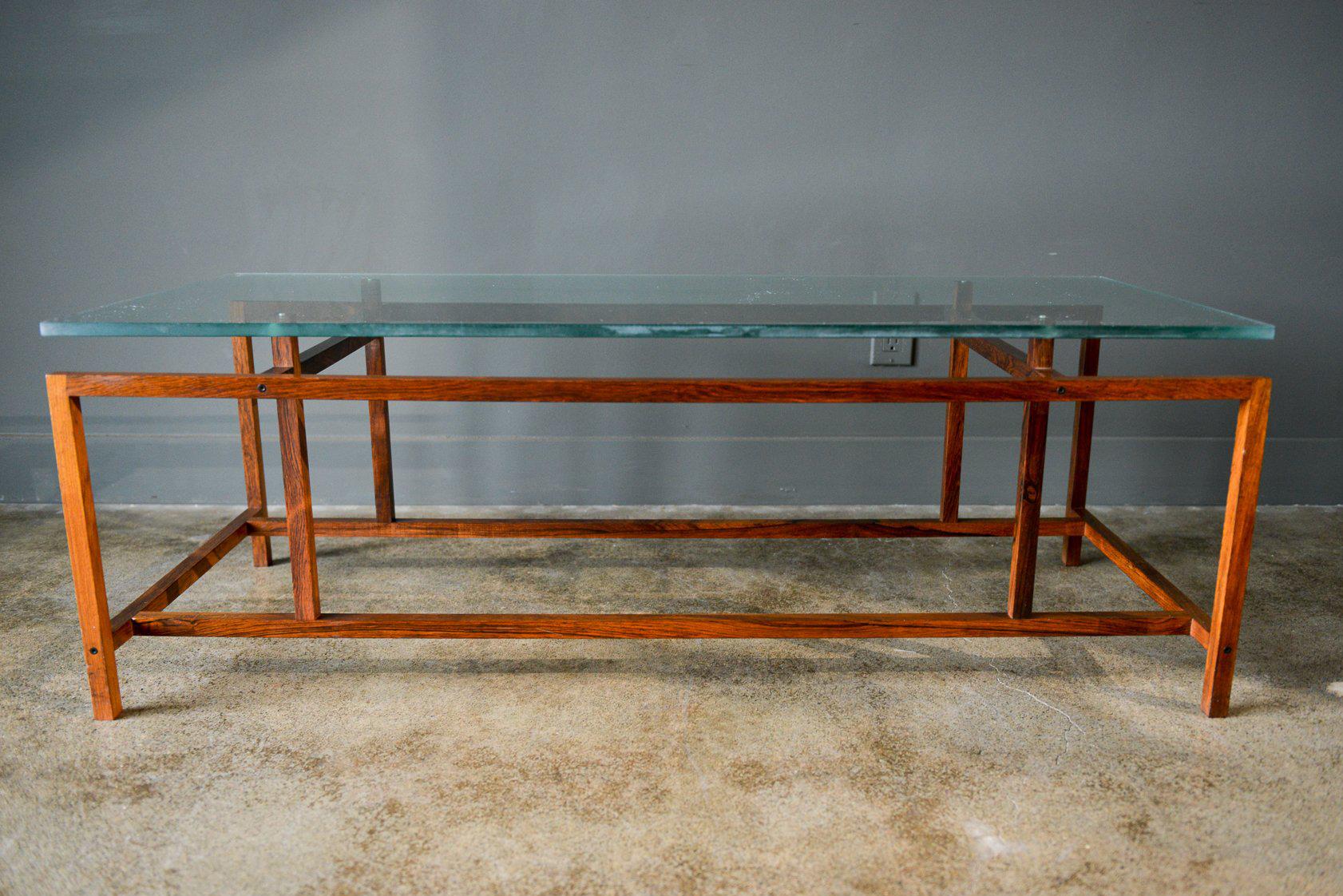 Rosewood and glass coffee table by Henning Norgaard for Komfort of Denmark, circa 1965. Original notched glass with very light wear, one small mark as shown in photos. Rosewood frames in very good condition. 

Measures 47