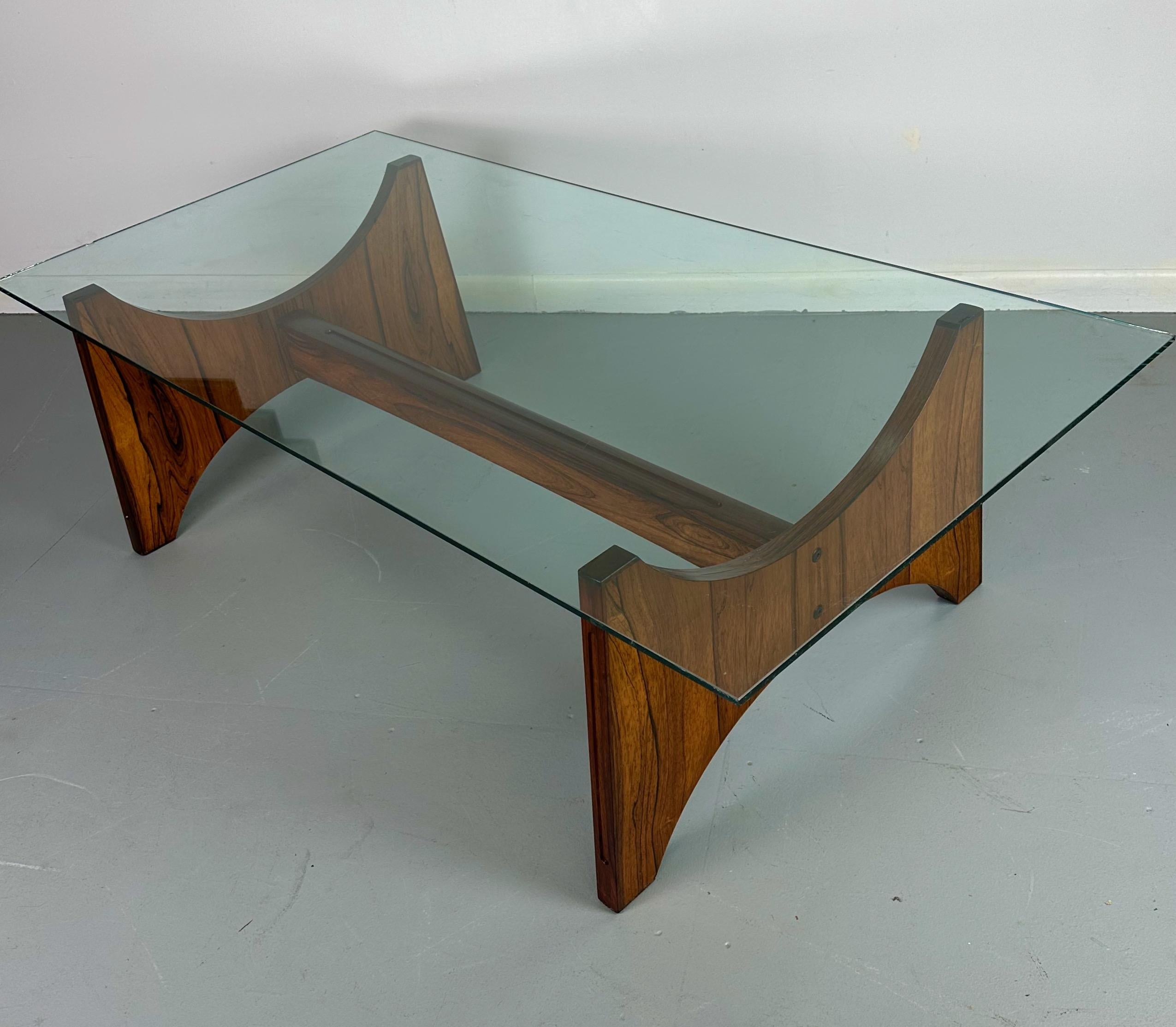 A vintage 1970s Danish coffee table by Torpe Mobelfabrikk Norway in Brazilian rosewood.This table has two arch shaped end pieces with a cross bar connecting them. There is an incised design on the edge of each piece. In good original condition with