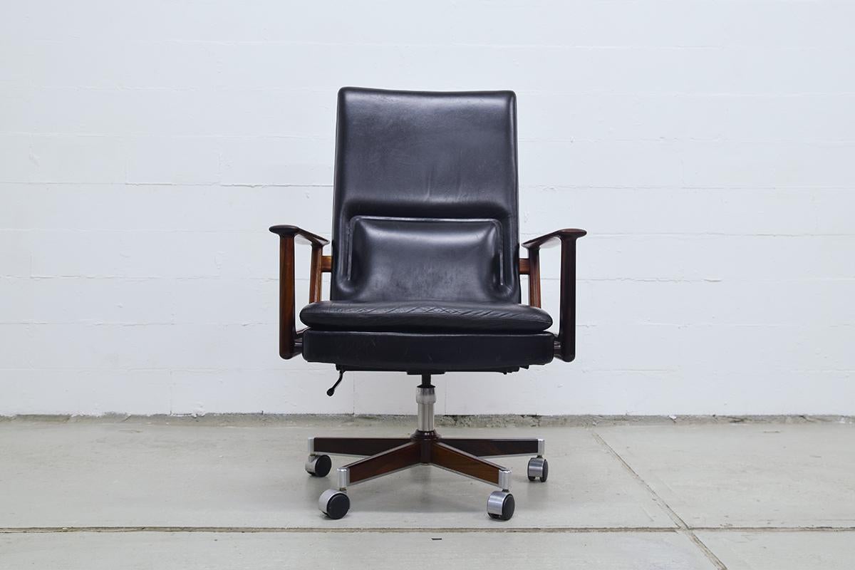 Danish Modern rosewood and leather executive desk chair designed by Arne Vodder in the 1960s. With a rosewood five star base on casters. So it still can be used as an official desk chair. The height is adjustable and can be tilted backward.