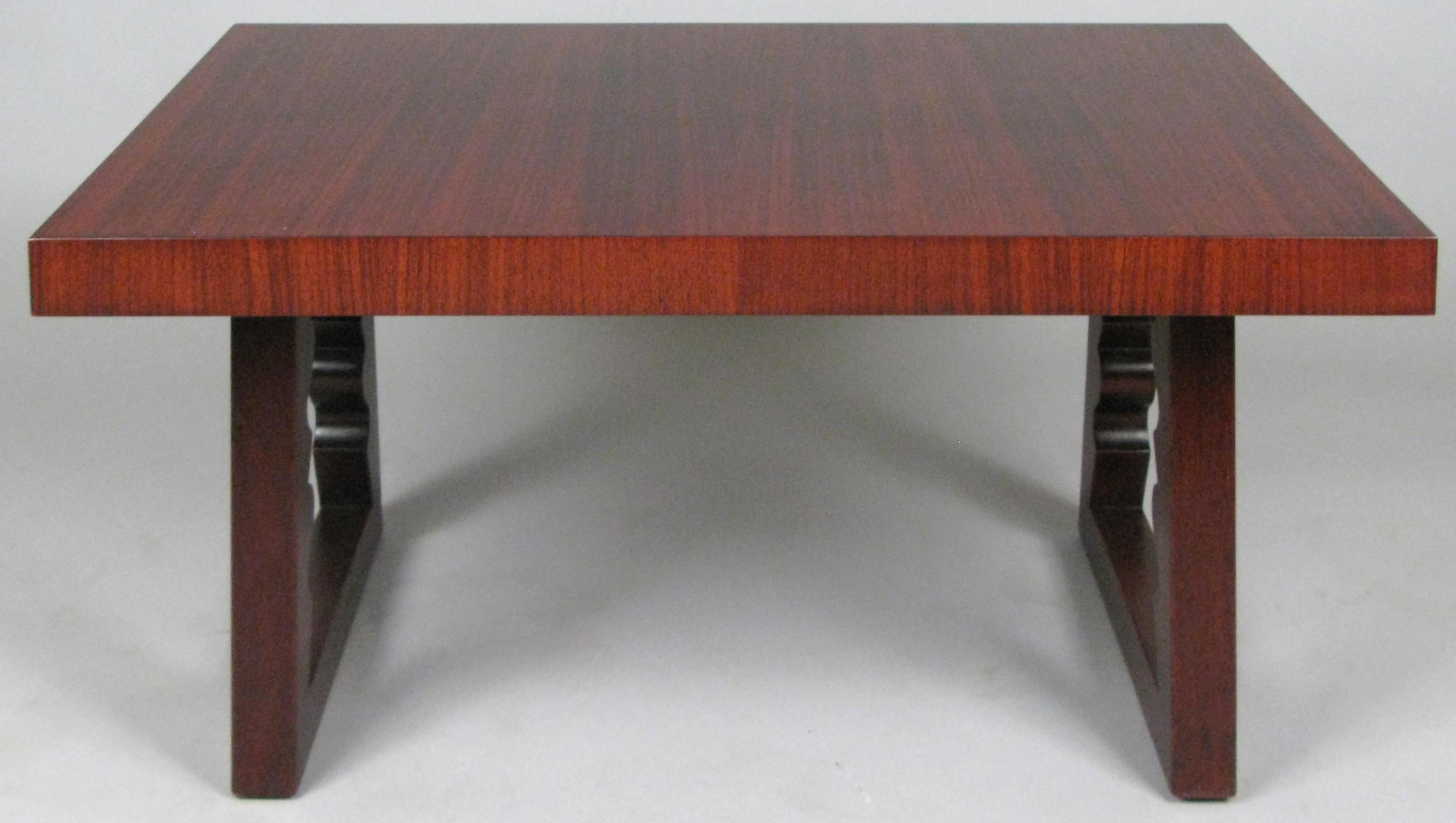 A beautifully detailed rosewood cocktail table designed by Andrew Szoeke, circa 1948. With a rectangular top and mahogany bases with sculpted details on the interior of the legs. Gorgeous rosewood graining.