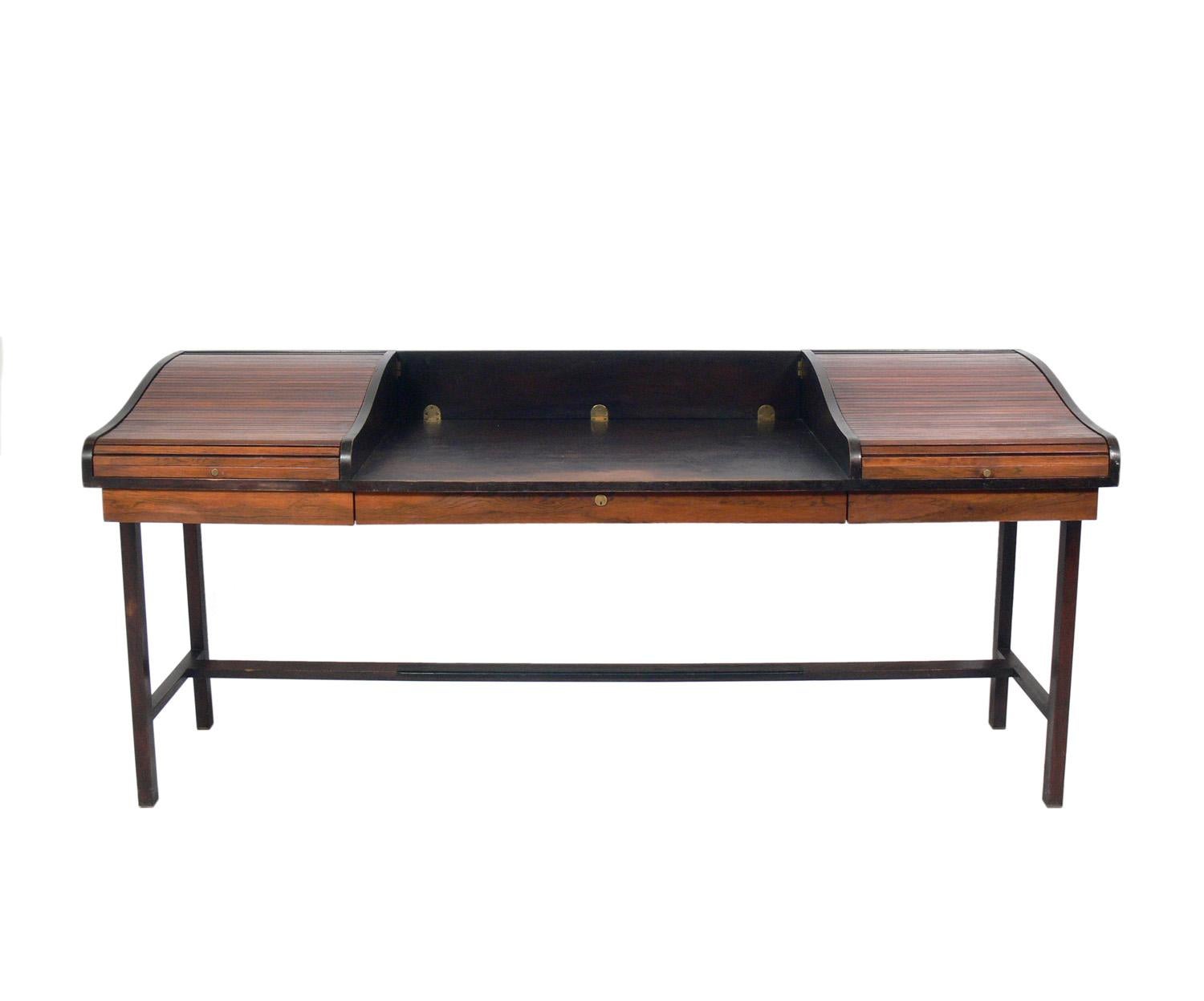 Rosewood and mahogany roll top desk, designed by Edward Wormley for Dunbar, American, circa 1960s. This piece is being refinished and will look incredible when completed. The price noted includes refinishing. 

The tambour roll up doors open to