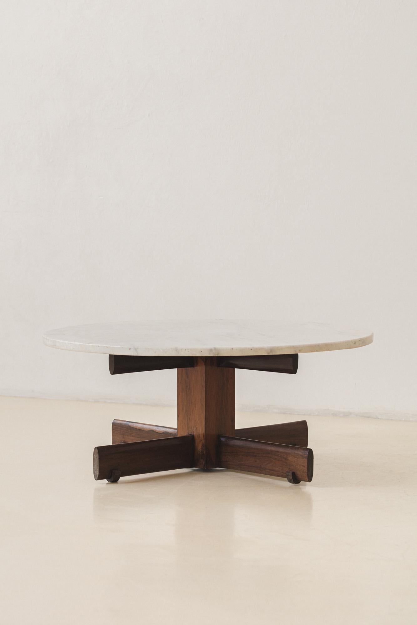 This round coffee table was produced in the 1960s, with both feet and top cross-shaped.

This practical four-seat dining table features very well-built fittings, as the cross supports the top and the four charming wood pieces that touch the floor.