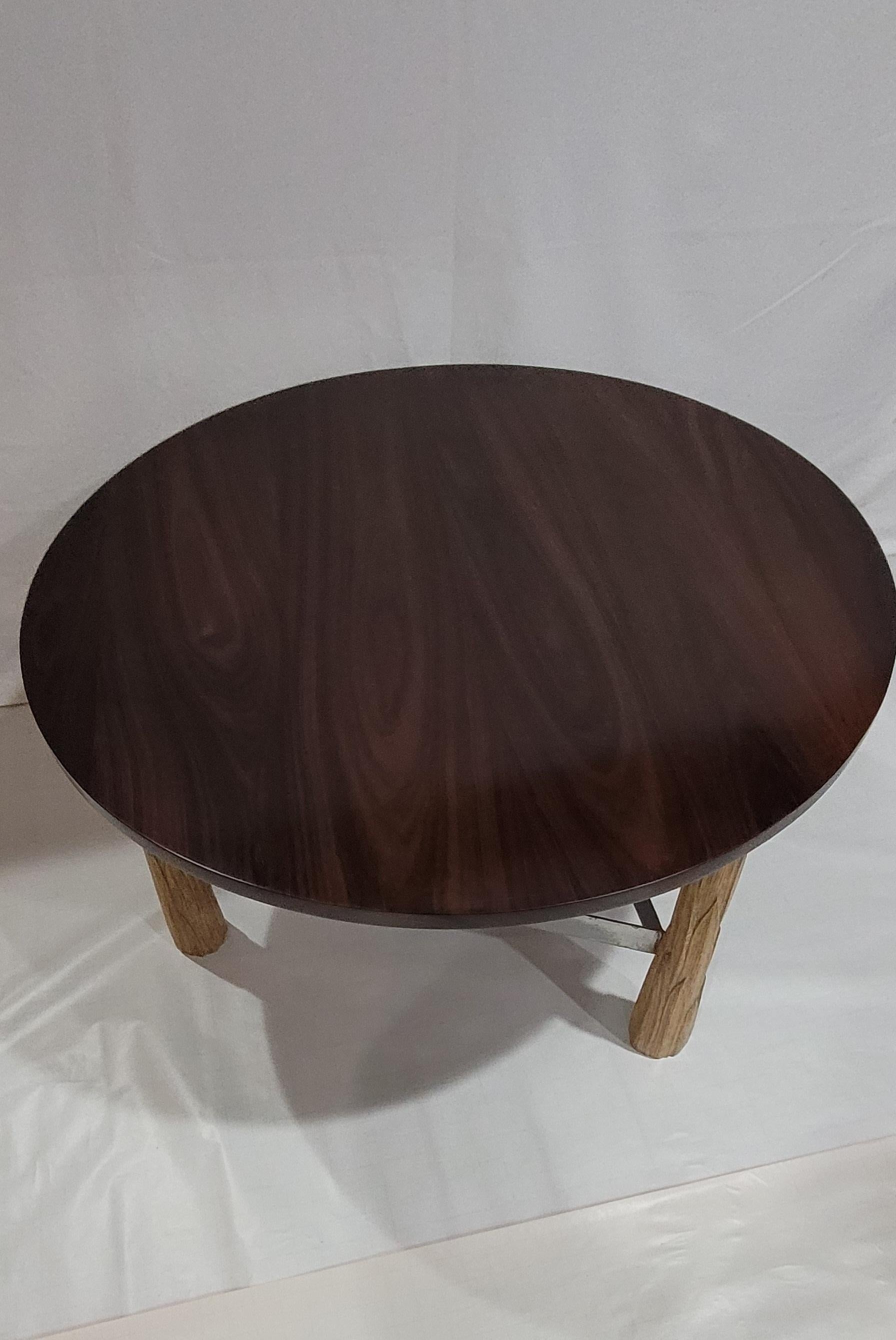 Equilibrato nelle proporzioni e ricco di texture, questo tavolino centrale unisce l'eleganza naturale alla forza moderna. Il piano rotondo è realizzato in palissandro massiccio, ammirato per le sue venature profonde, la ricchezza tonale e la
