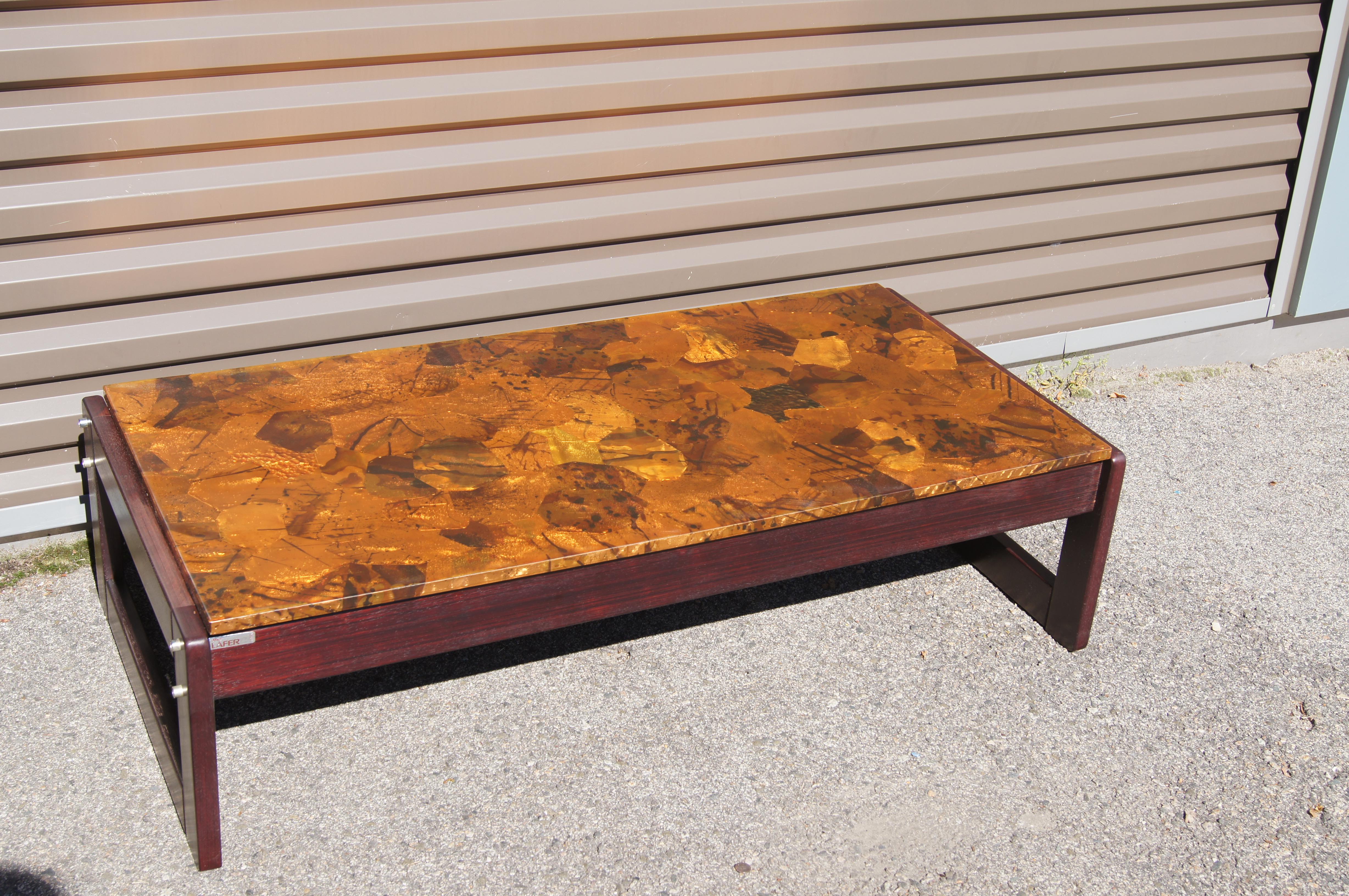 Conçue par le moderniste brésilien Percival Lafer, cette table basse en bois de rose jacaranda présente un cadre rectangulaire audacieux avec des ferrures apparentes. La partie supérieure est fabriquée en cuivre patchwork magnifiquement patiné.