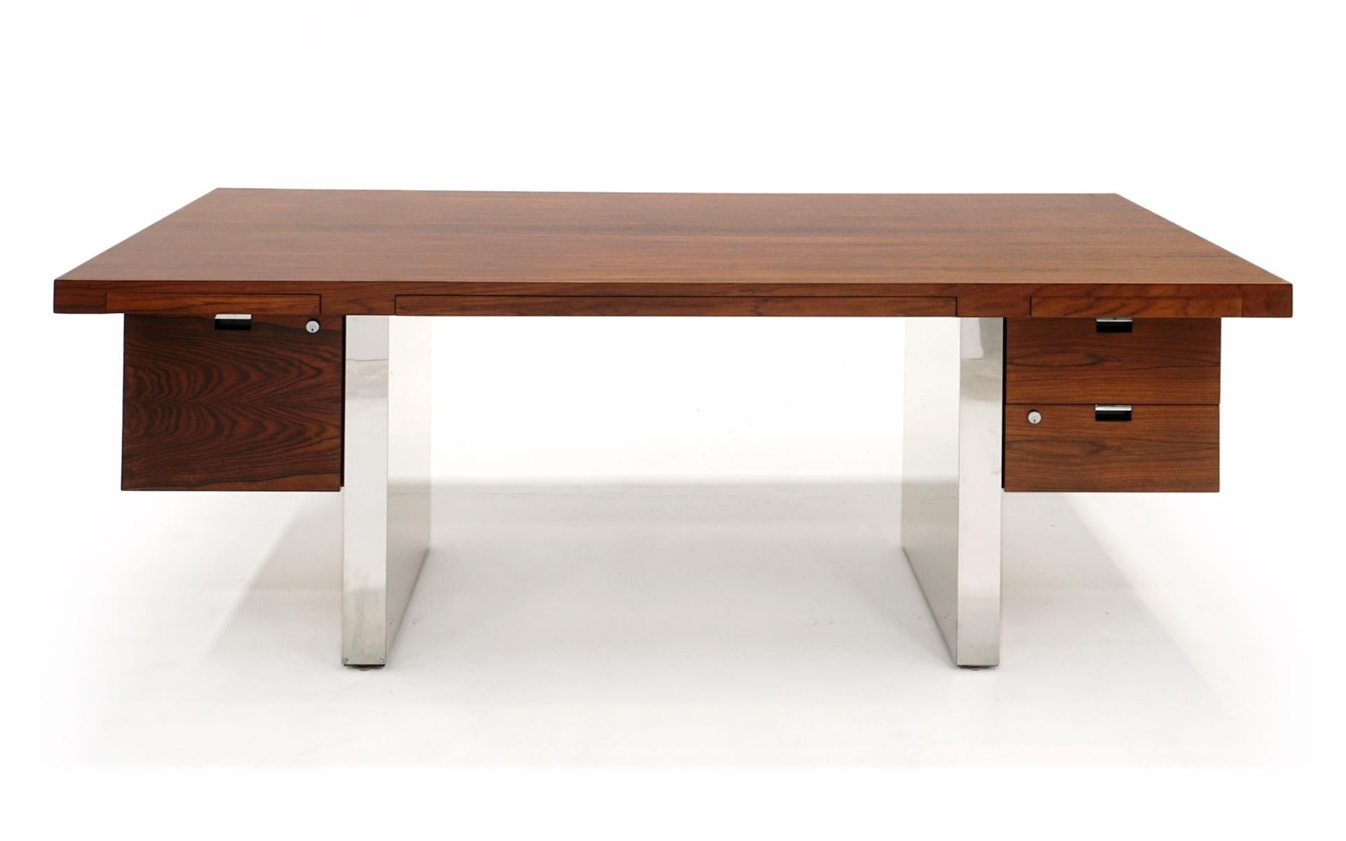 Brazilian rosewood and aluminum floating top desk by Roger Sprunger for Dunbar.  Three shallow drawers are carved out of the desk top: two side drawers and one wide center drawer.  In addition there are suspended deeper drawers on each side for