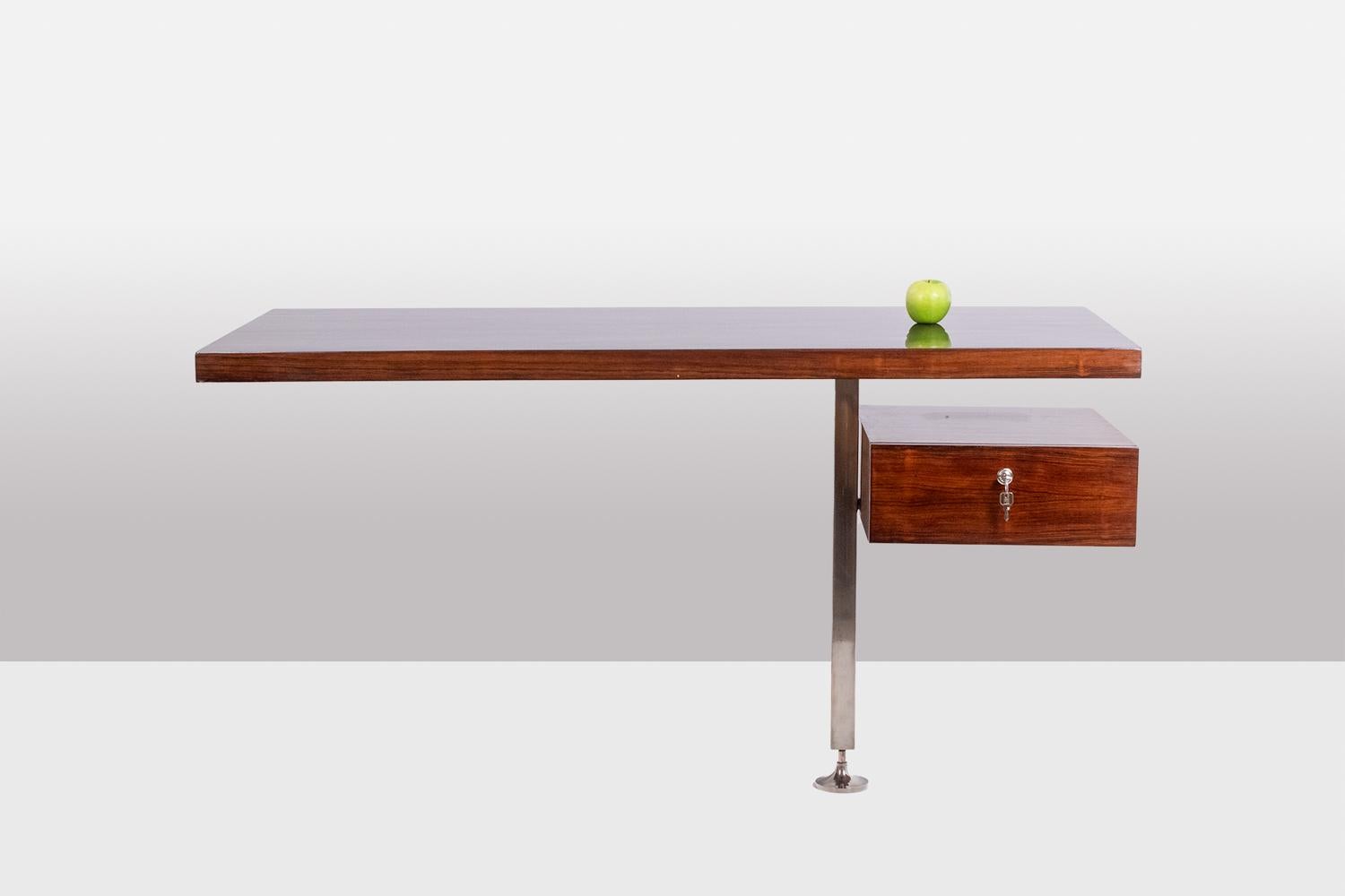 Rosewood wall desk, with its side box opening with two drawers. Chromed metal base. Has his key. 

Work realized in the 1970s.

Dimensions: H 77 x W 140 x D 70,5 cm

Reference:LS60091254D