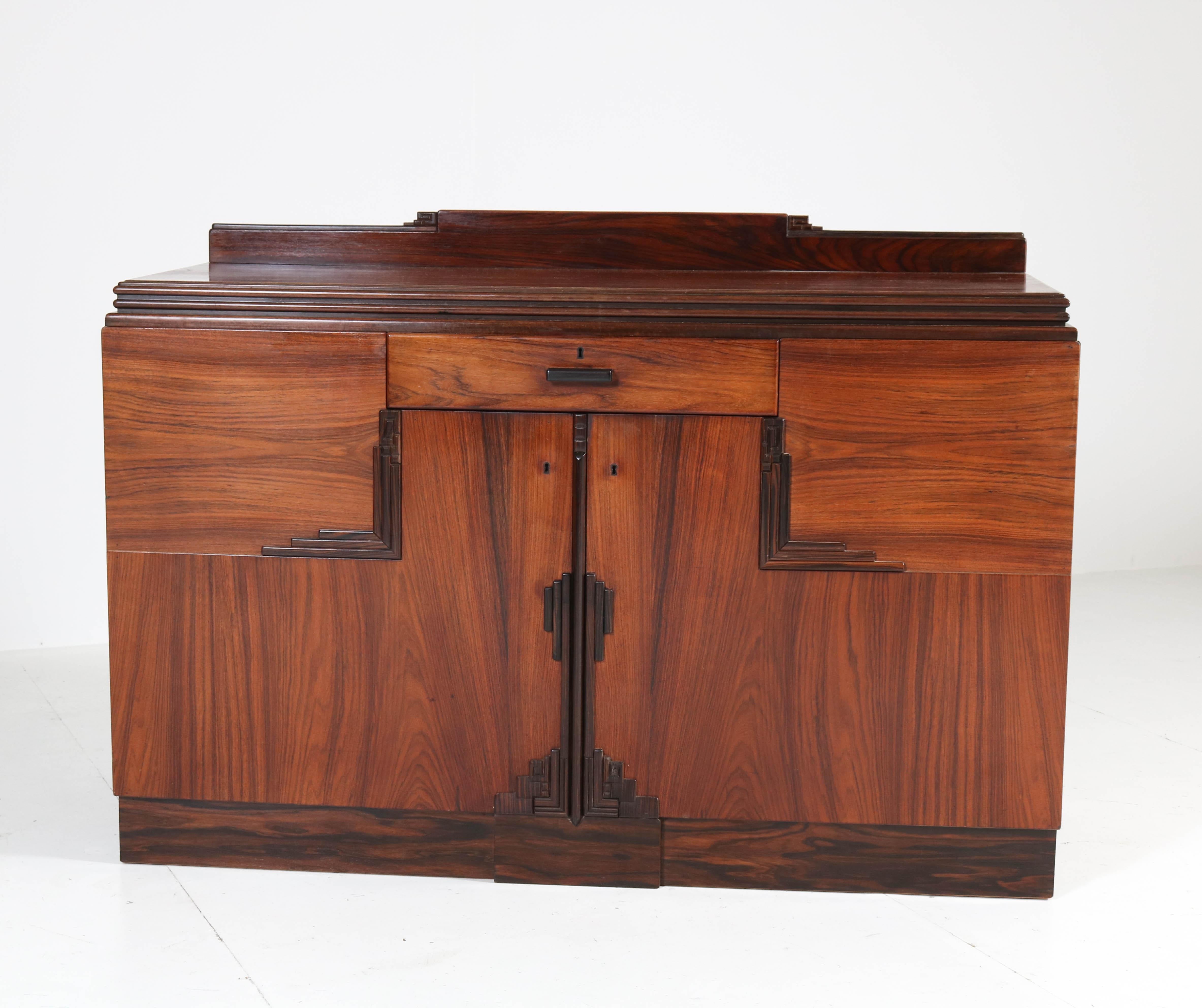 Magnificent and rare Art Deco Amsterdam School credenza or sideboard.
Design by Fa. Drilling Amsterdam.
Striking Dutch design from the 1920s.
Rosewood veneer with solid ebony Macassar lining.
In very good refinished condition with minor wear