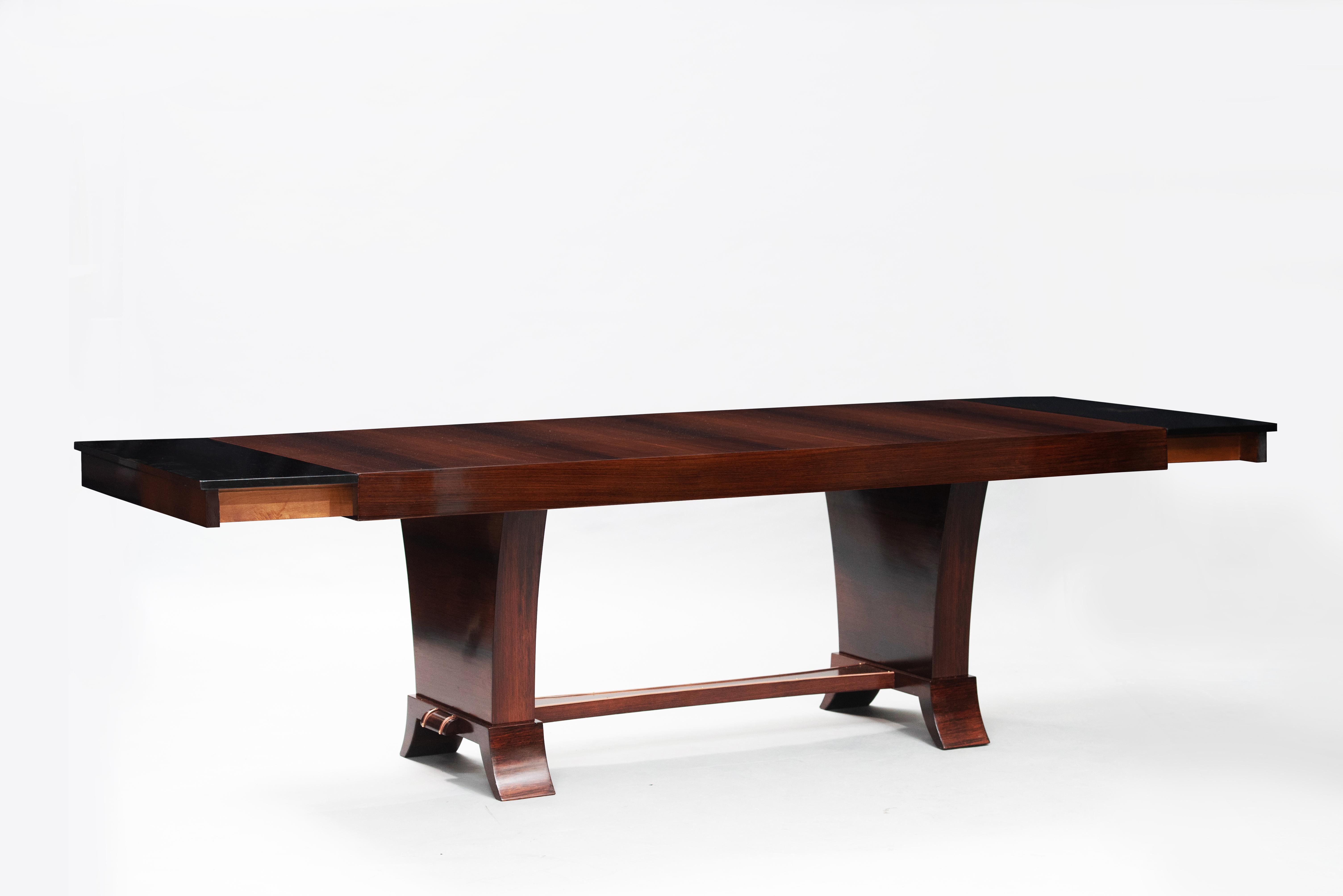 Art Deco rosewood extendable dining table with copper friezes on the legs.
Width: 200cm (closed), the extension leaves are not in rosewood veneer.
 