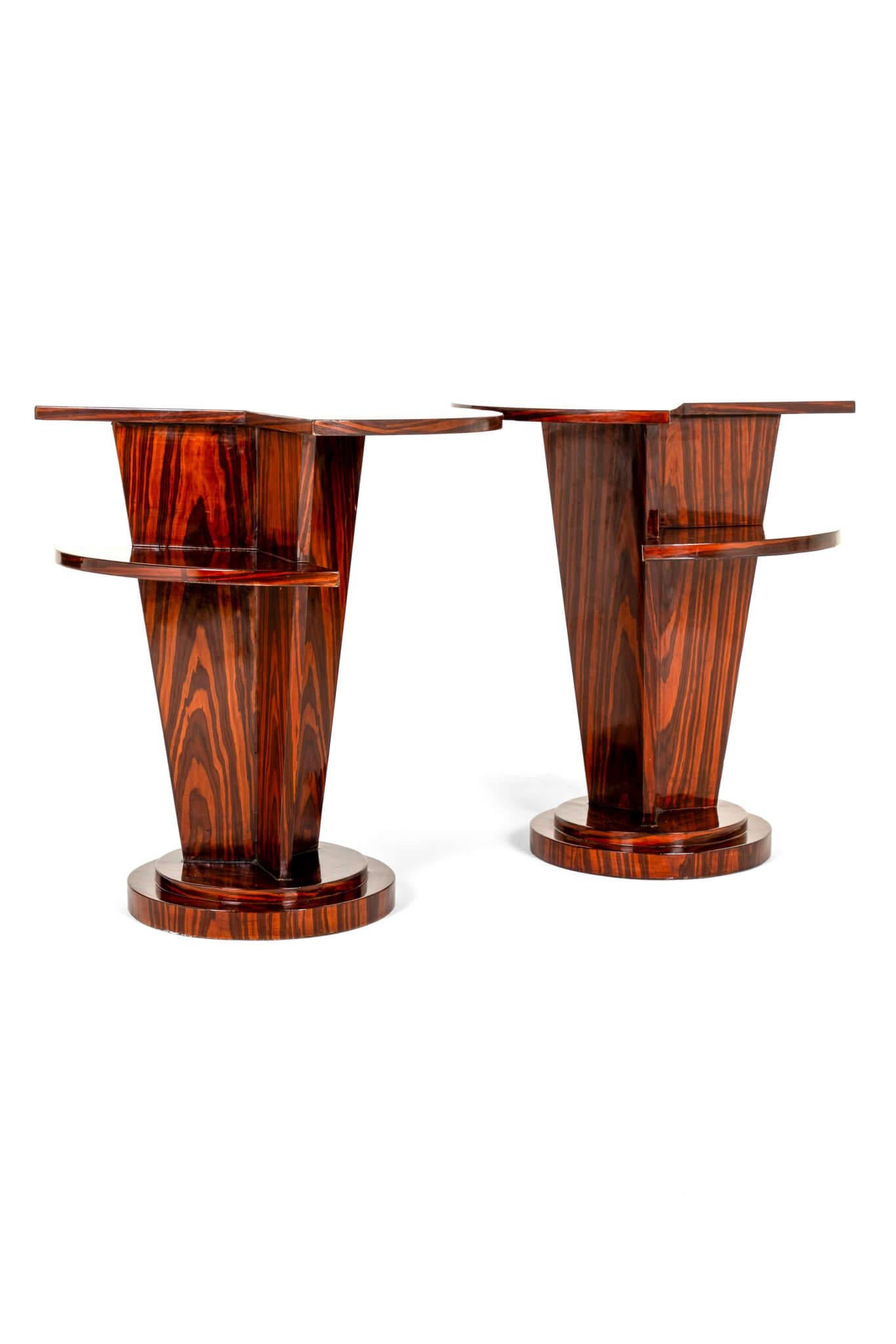 Ein auffälliges Paar Beistelltische im Art-Déco-Stil aus poliertem Palisanderfurnier in Makassar-Optik.

Zweistufige Tischplatte mit rundem Ausschnitt auf einem zweistufigen Sockel.

Das Paar eignet sich hervorragend als Nachttisch oder