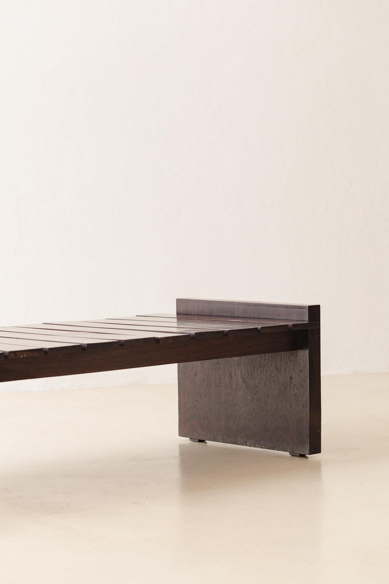 This gorgeous bench was produced in the 1960s by Celina Decorações, which signed one of the most modern lines of Brazilian furniture at the period. 

It consists of a very well-constructed piece in solid Rosewood, with slats rhythmically